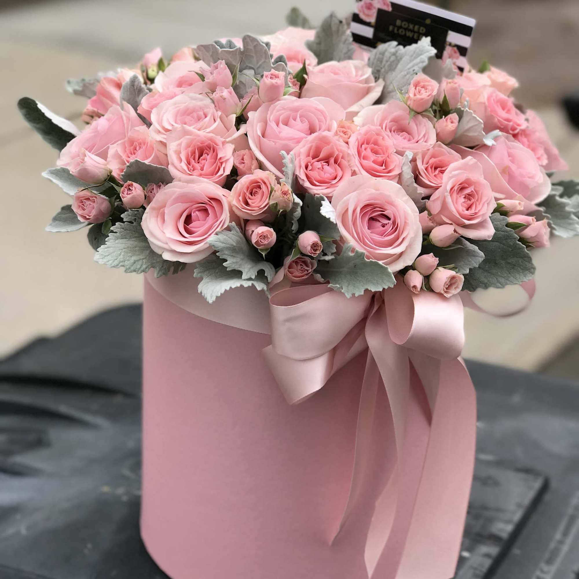 Pink roses arranged in a round pink box with a ribbon, photo 2 of 3