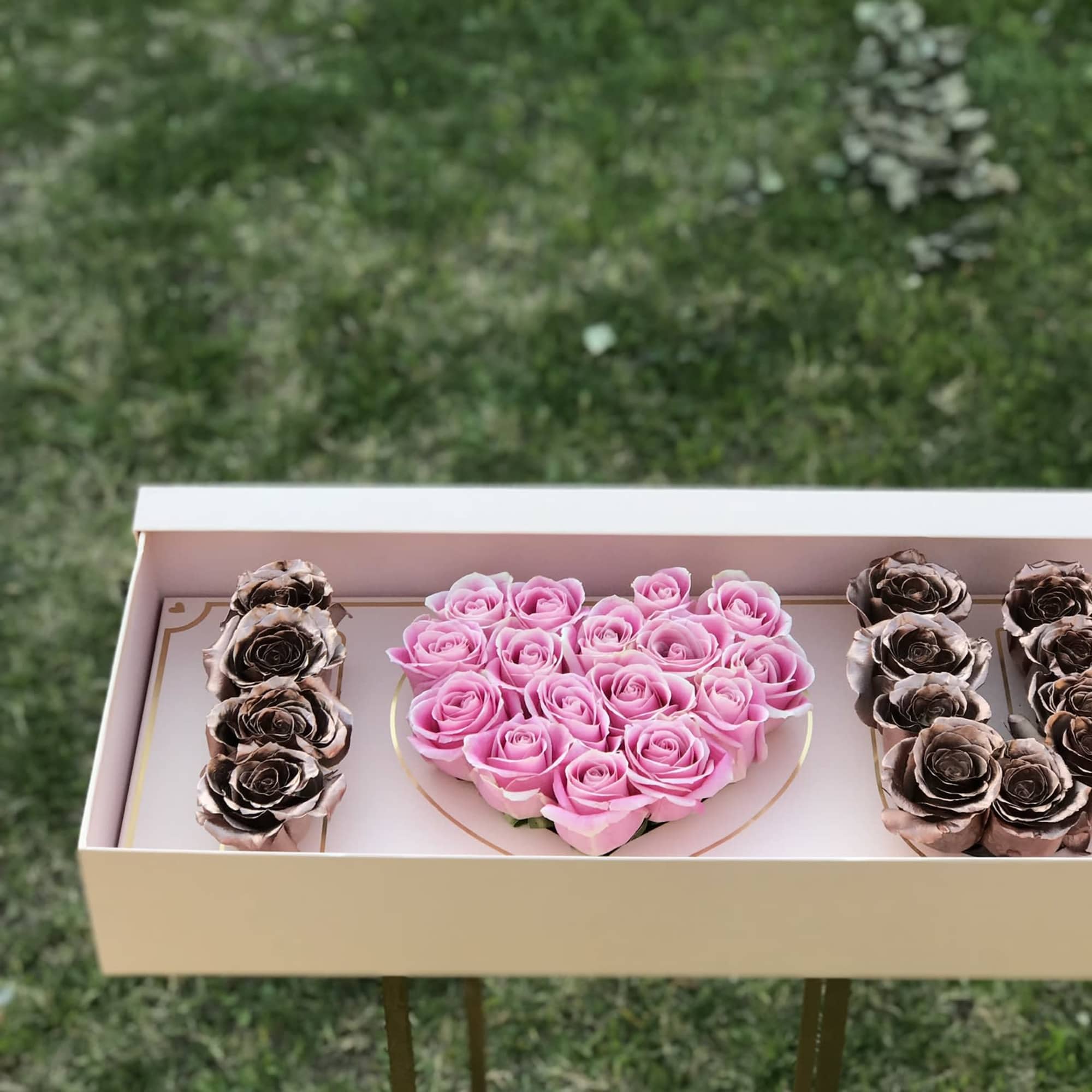 Heart-shaped pink rose arrangement in a gift box with metallic roses on the sides