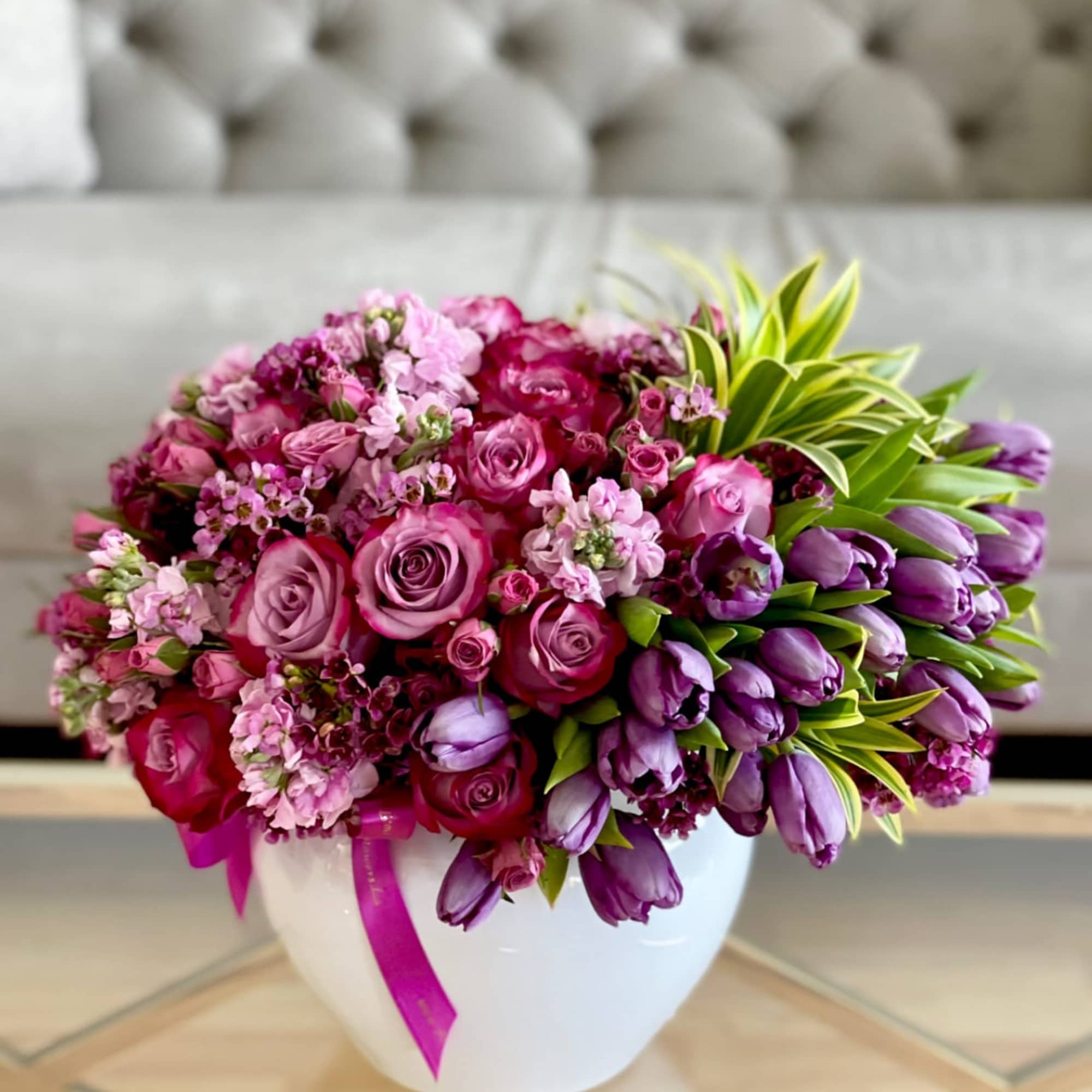 Pink and purple flower arrangement in a white vase