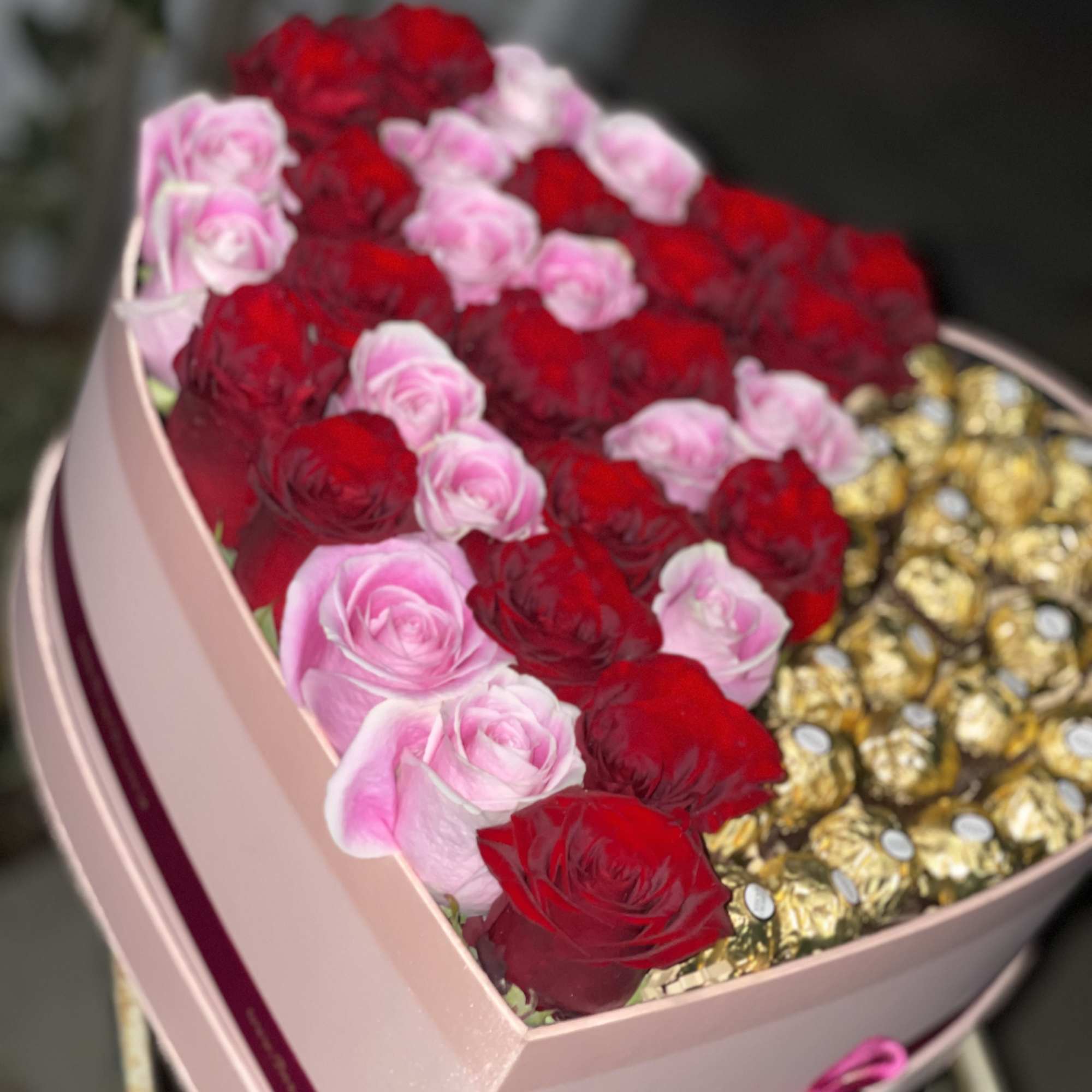 Heart-shaped box of red and pink roses with gold chocolates