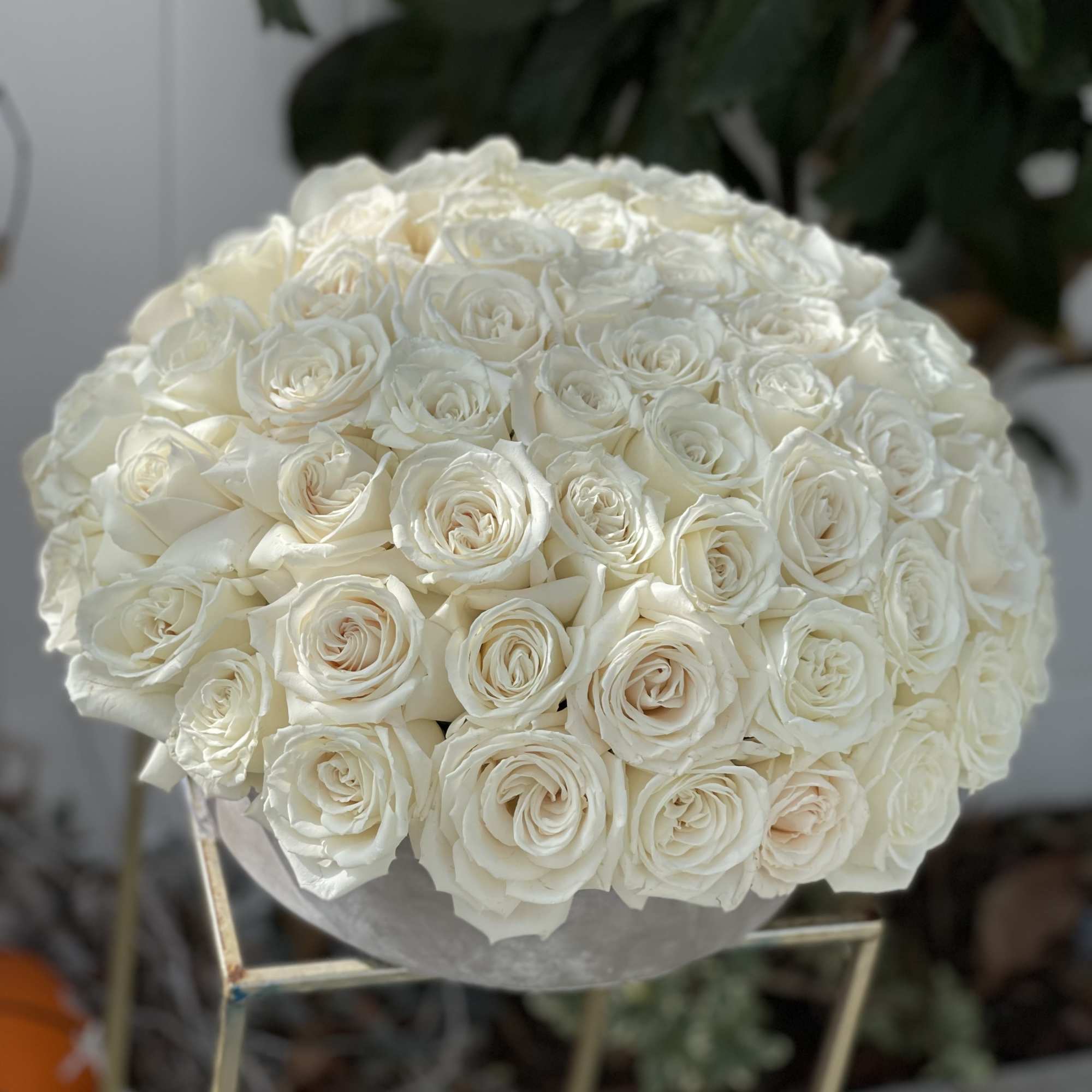 Round bouquet of white roses in a silver vase