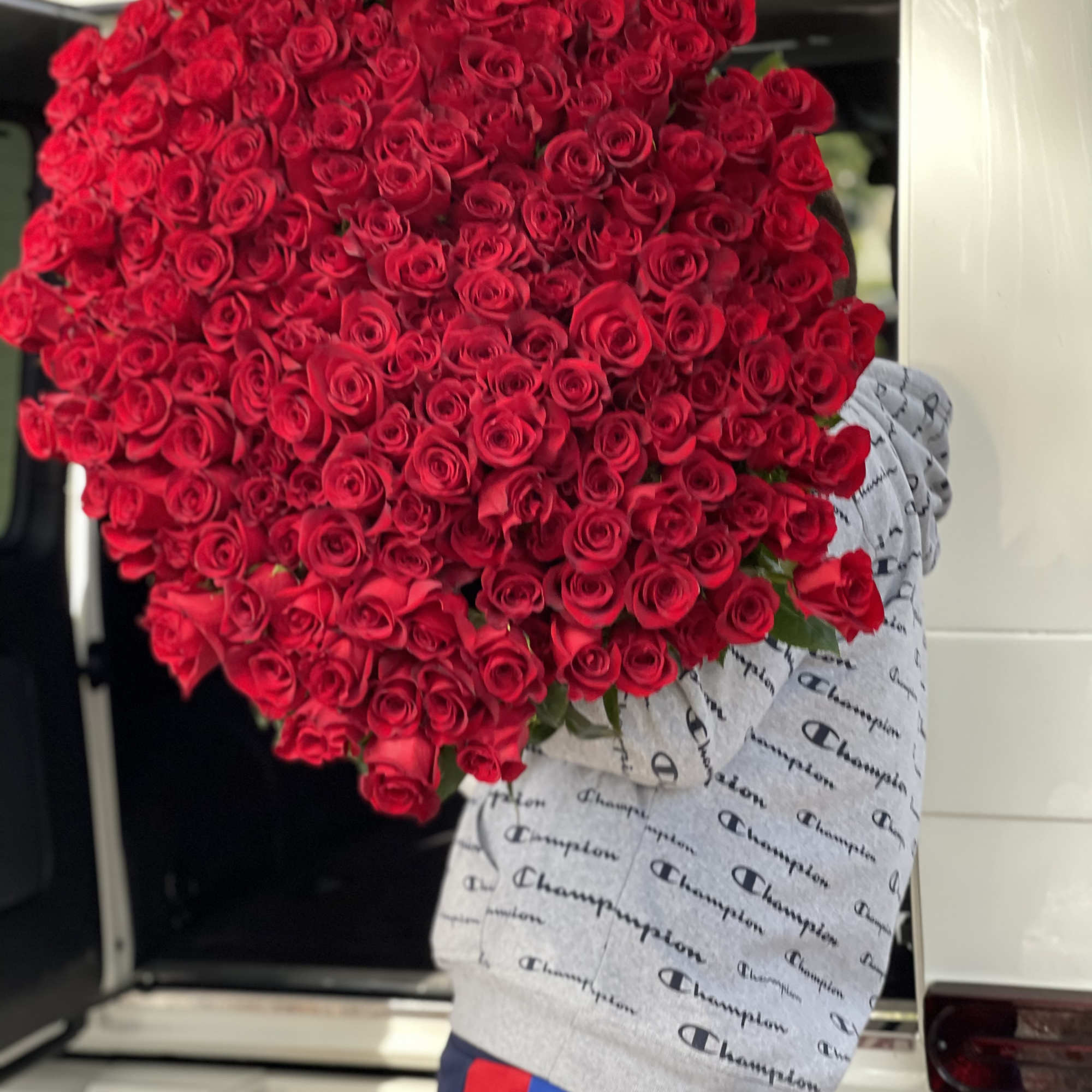 Large bouquet of red roses wrapped in printed paper