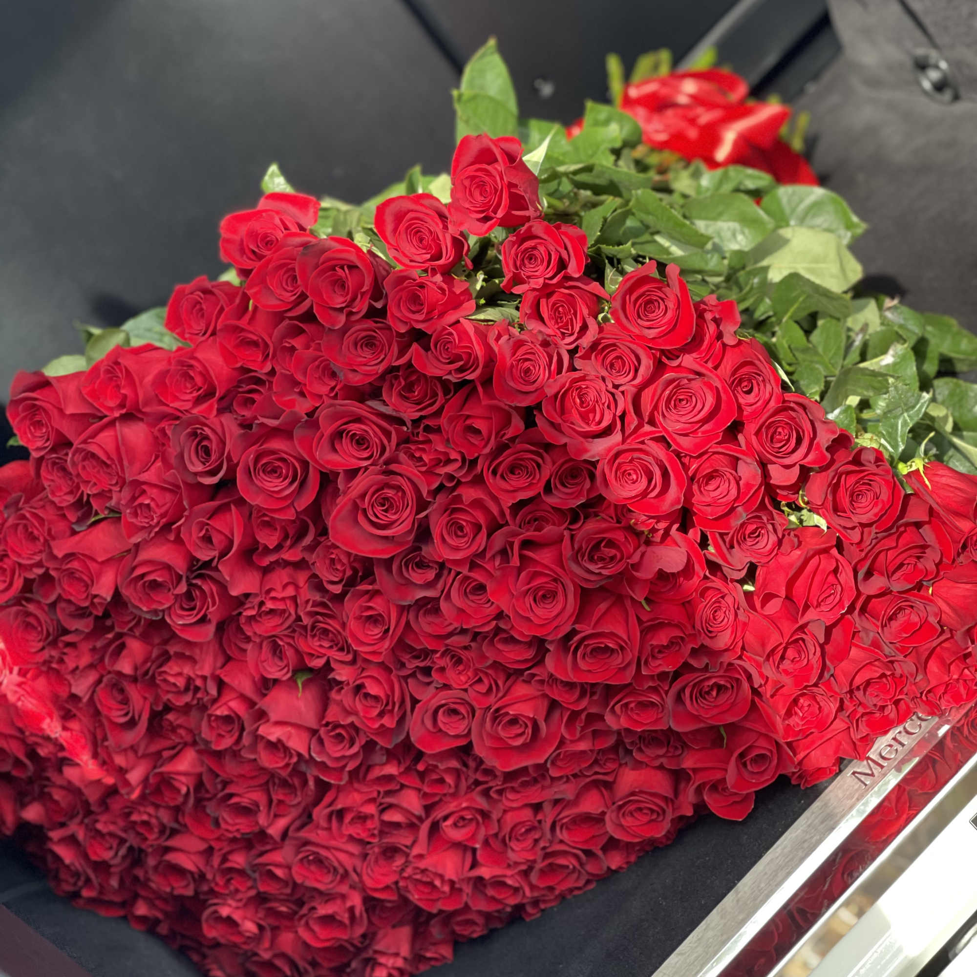 Large bouquet of red roses with green leaves