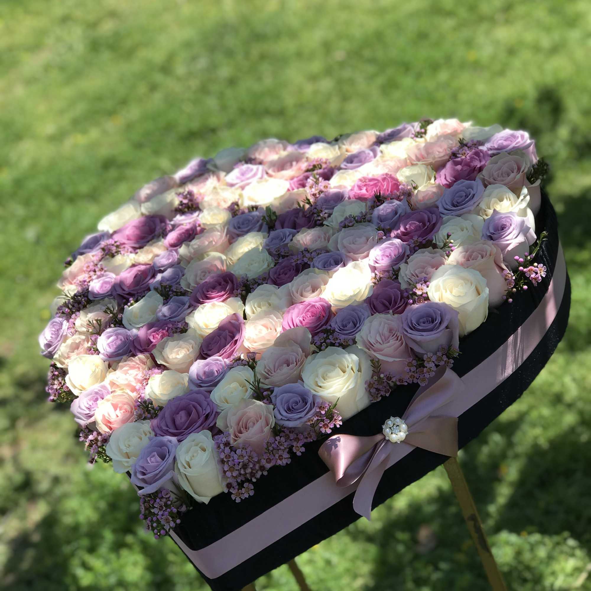 Heart-shaped box of pastel roses with a pink ribbon
