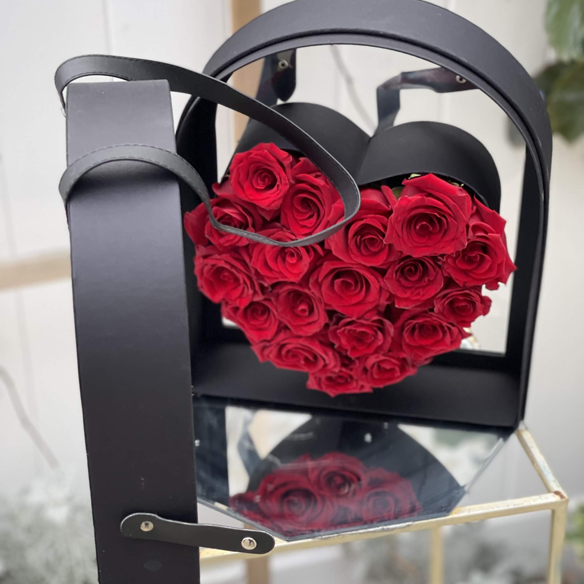 Heart-shaped red rose arrangement in a black gift box