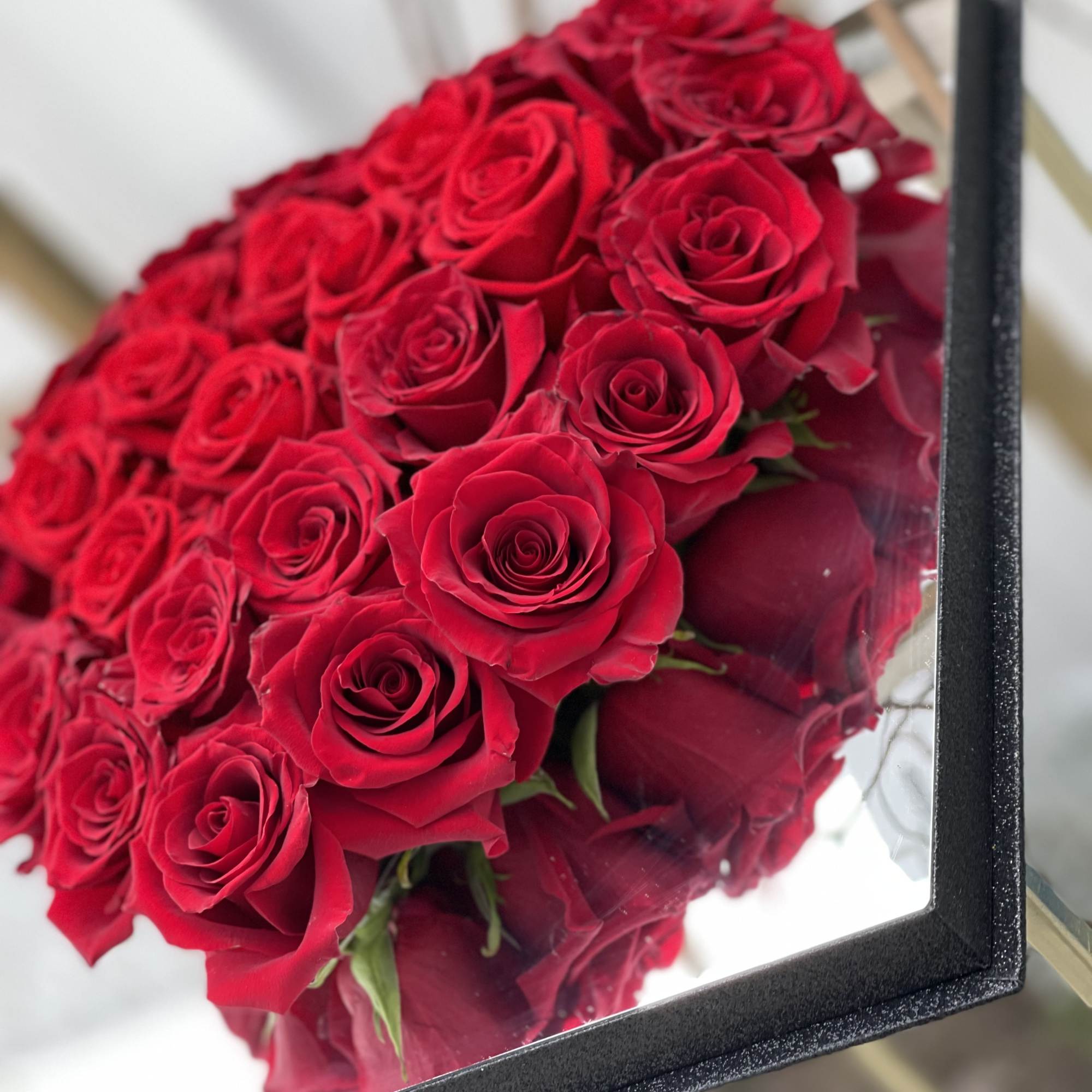 A bouquet of red roses in a black box
