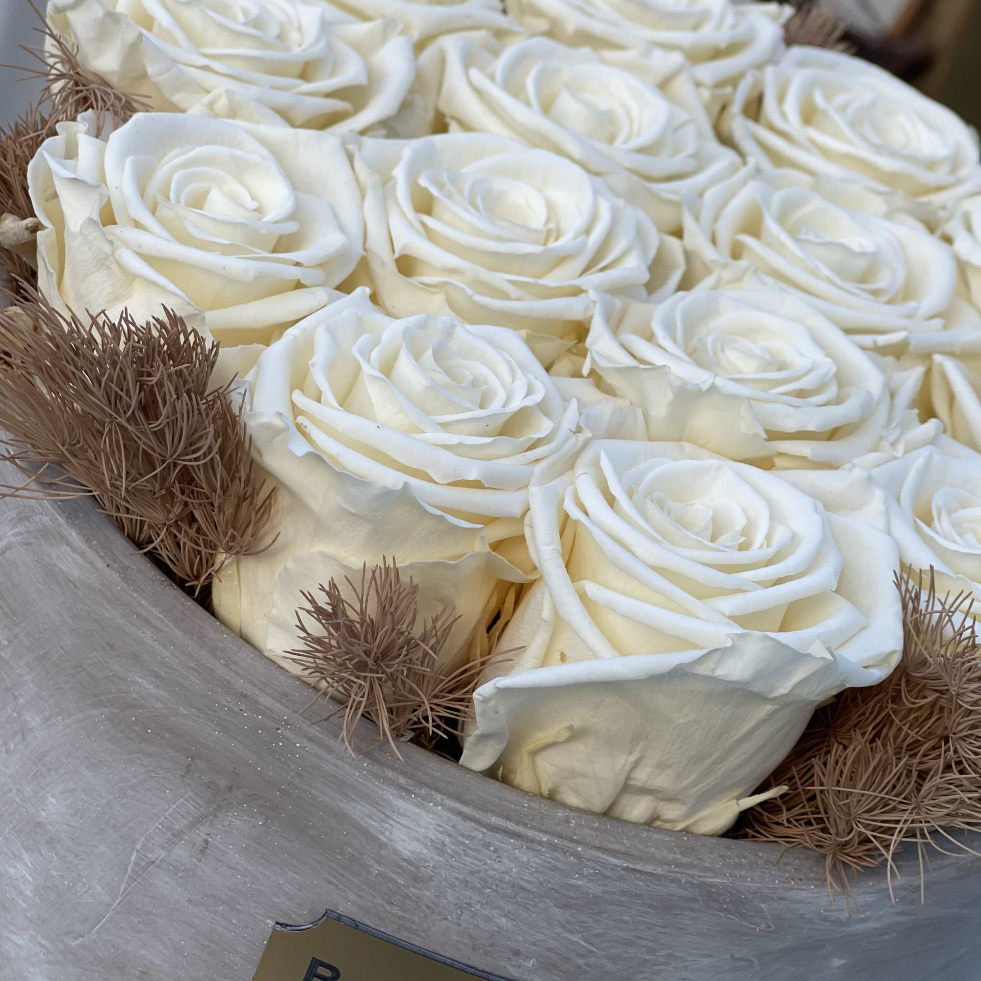Boxed bouquet of white roses with brown filler accents