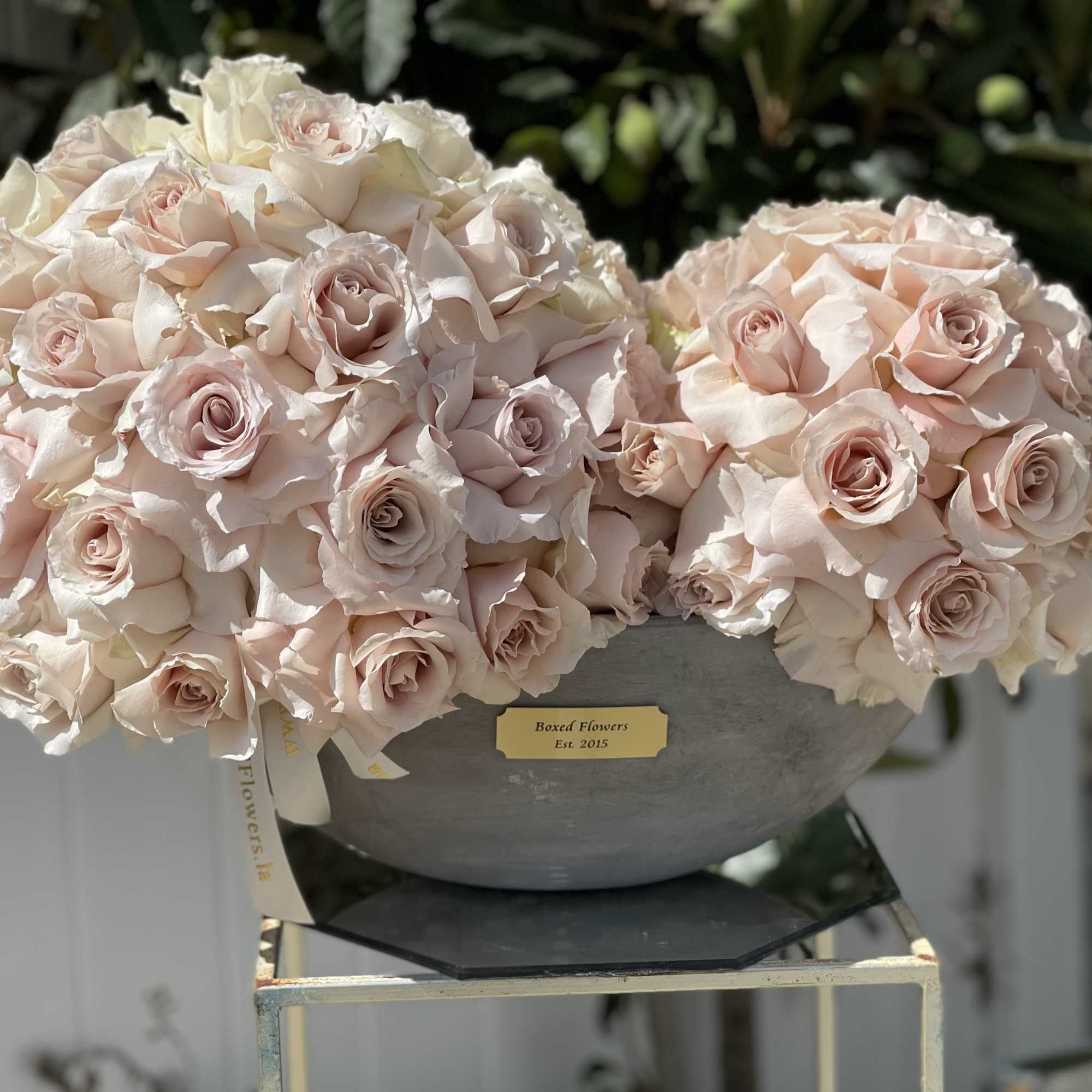Two pale pink rose bouquets in a gray bowl