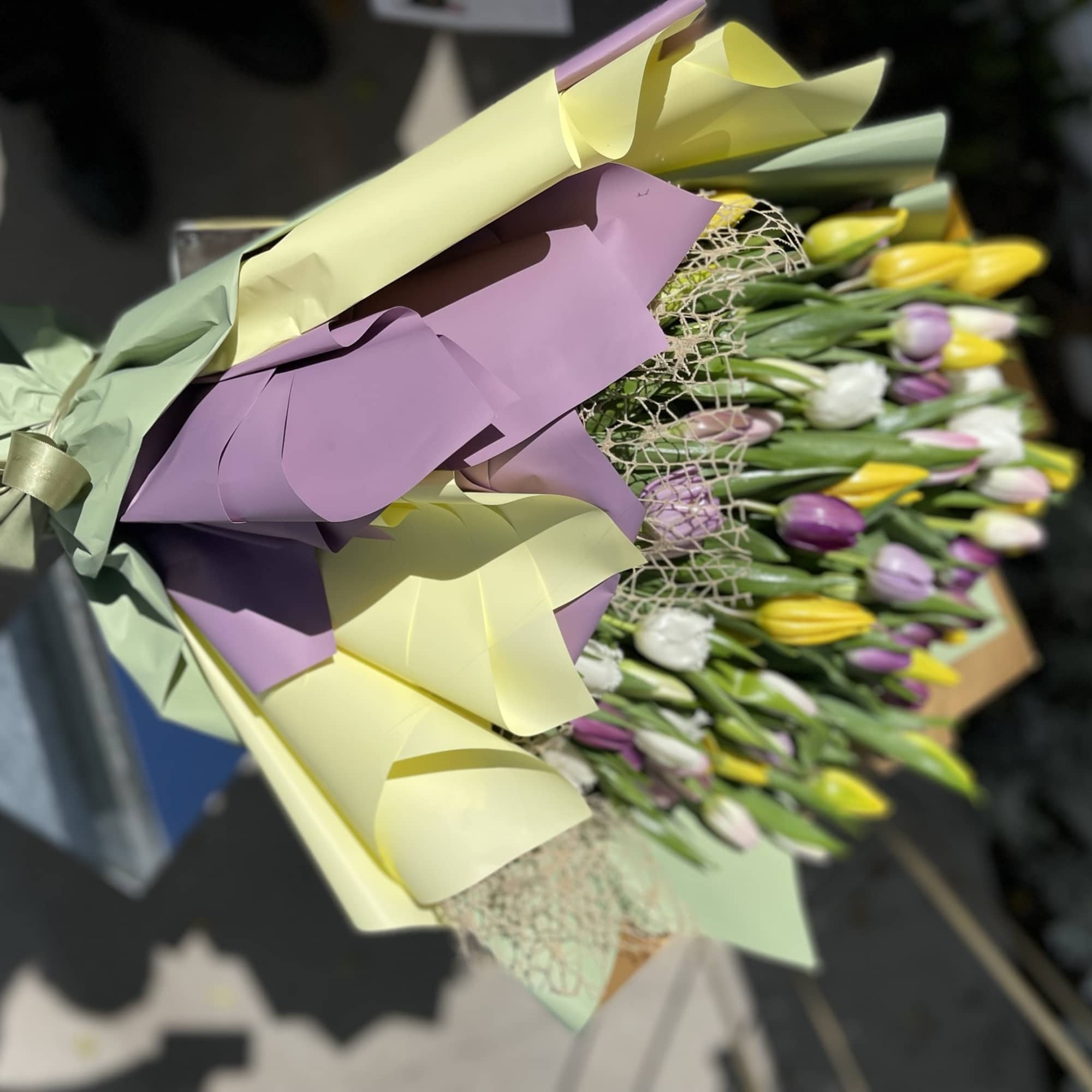 Bouquet of multicolored tulips wrapped in pastel paper