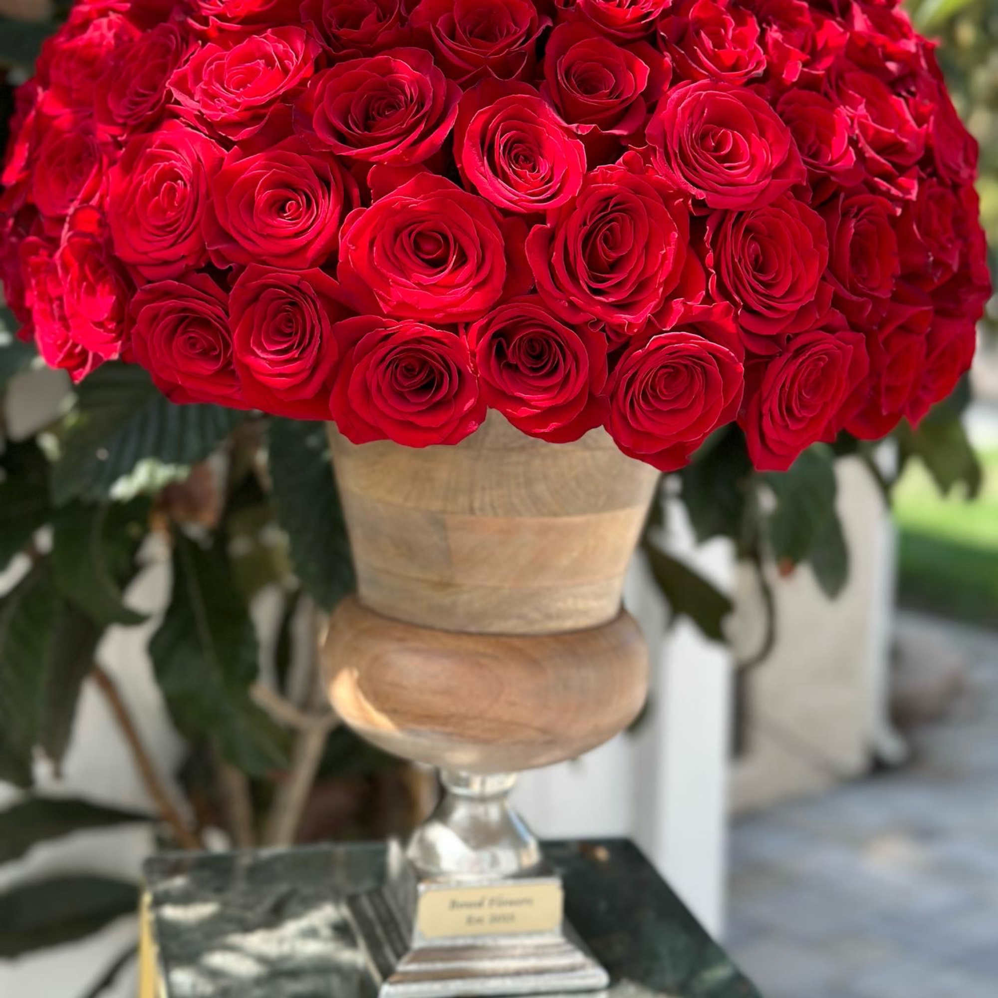 Large bouquet of red roses in a pedestal vase