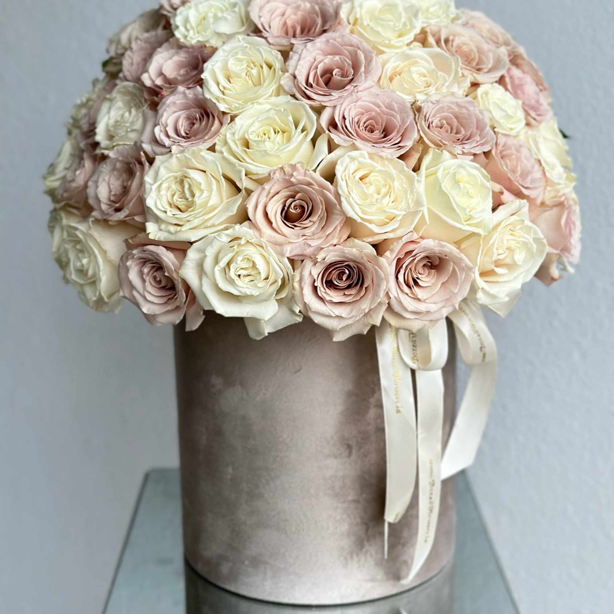 Round bouquet of blush and ivory roses in a velvet hat box