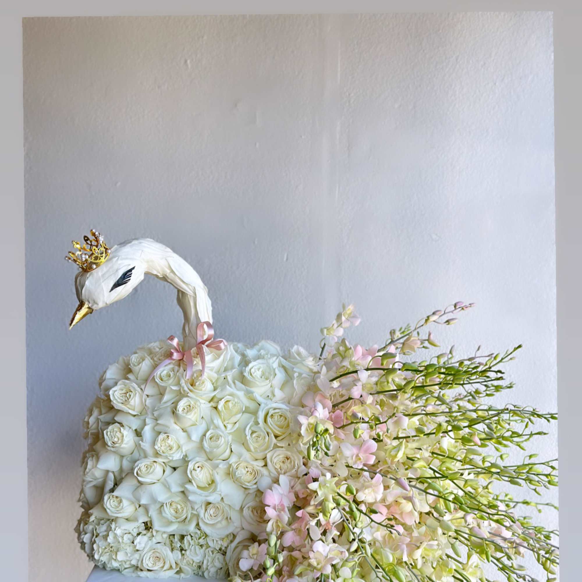 White rose swan arrangement with pink flowers on a stand