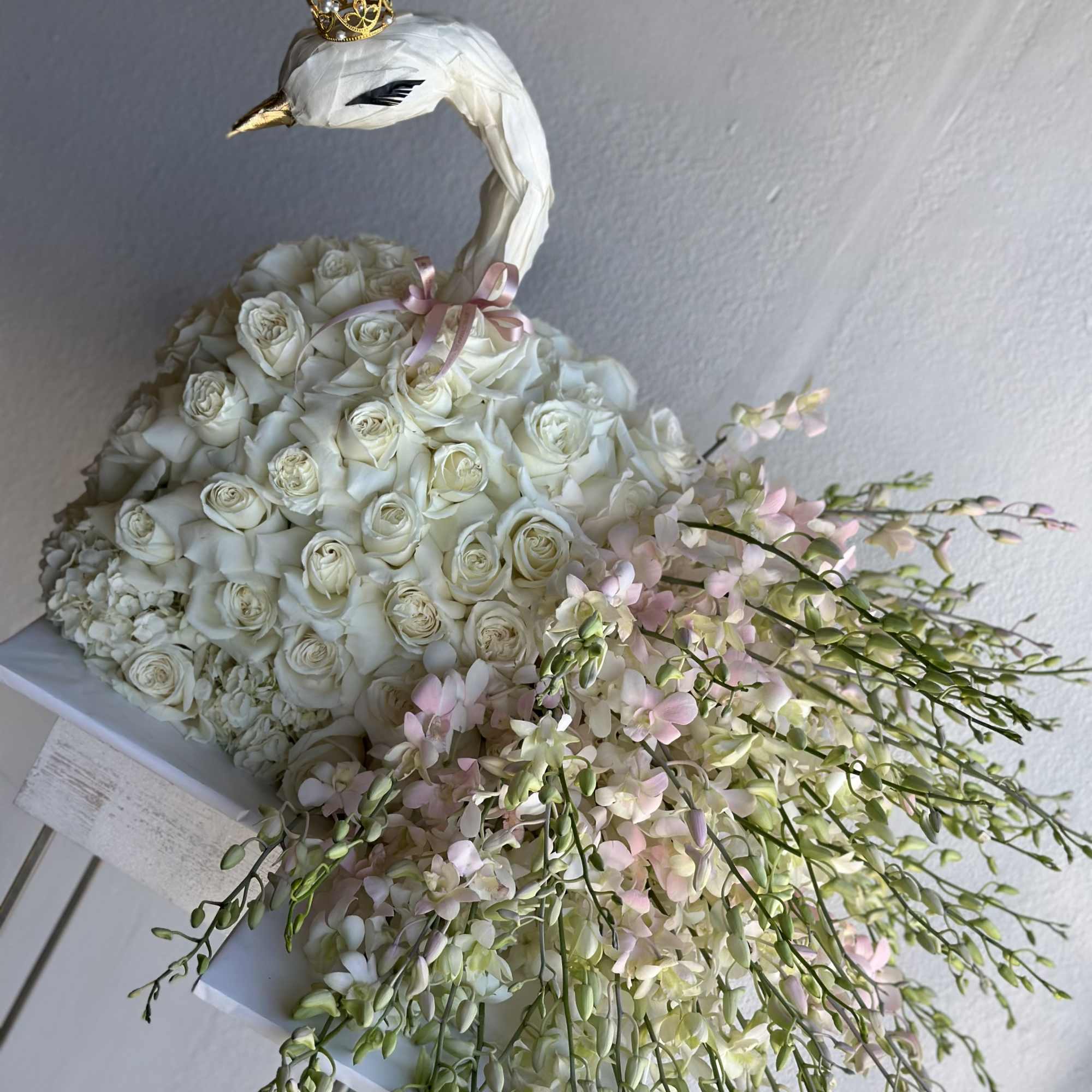 White rose swan arrangement with pink orchid sprays