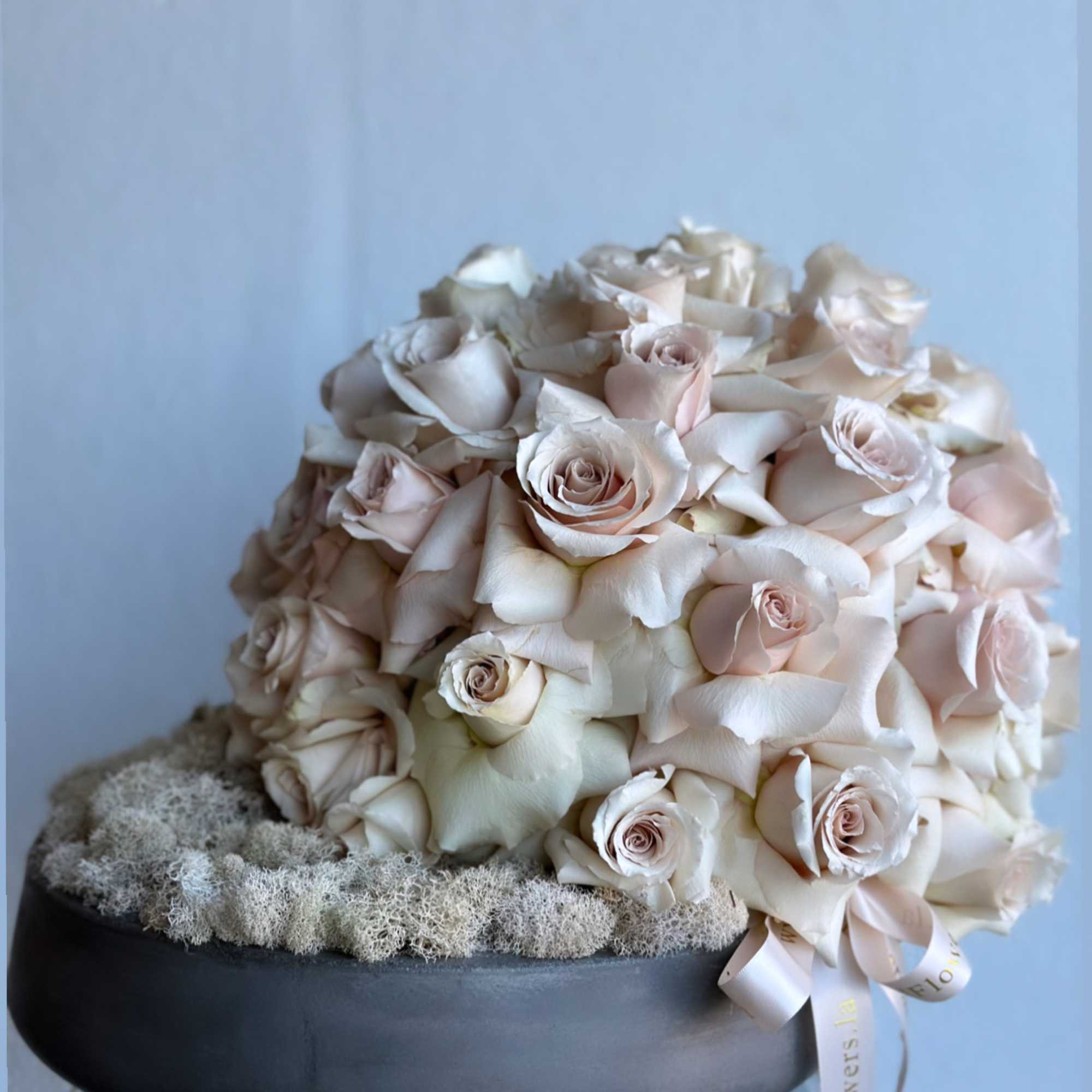 Round bouquet of pale blush roses in a black bowl