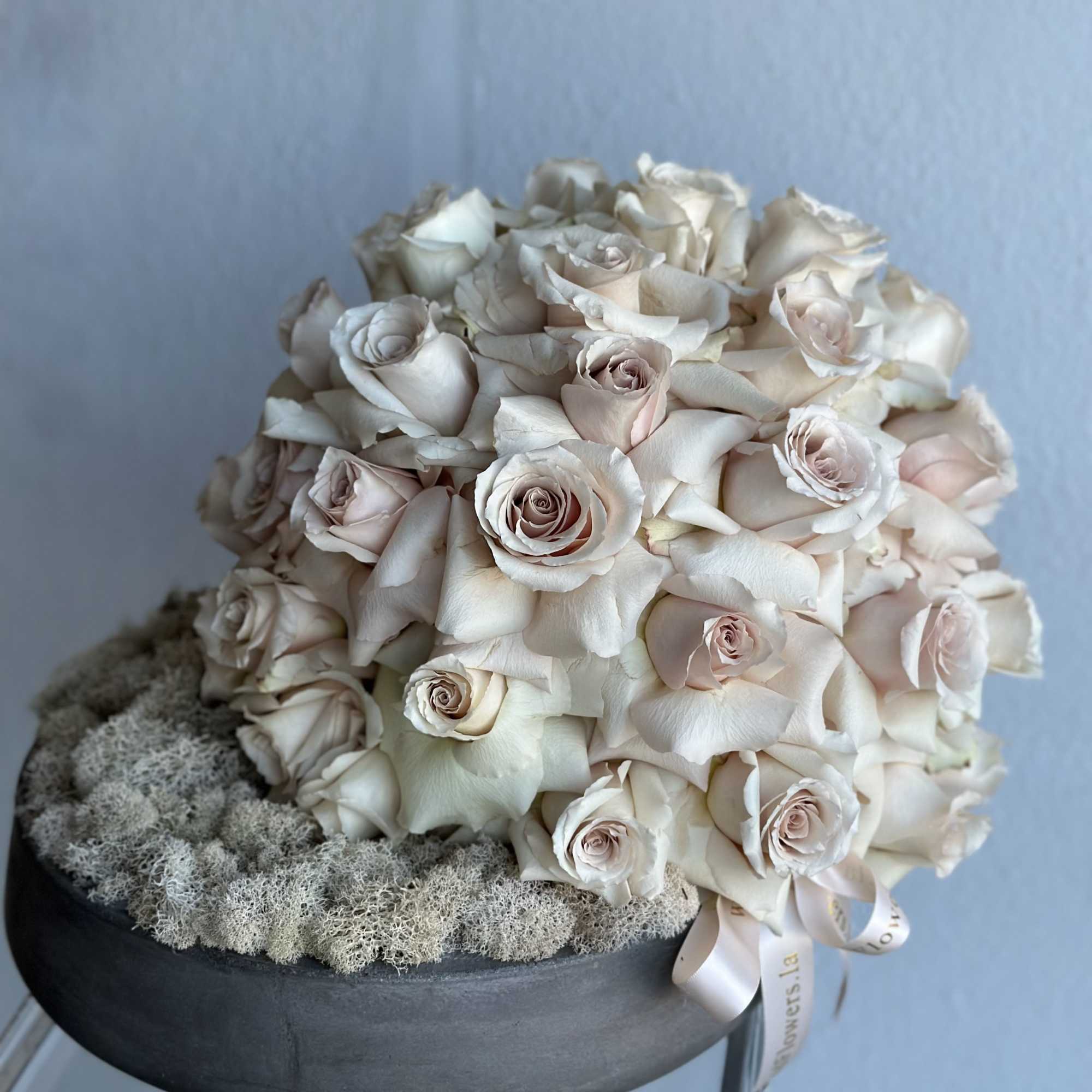Round bouquet of pale blush roses in a black hat box