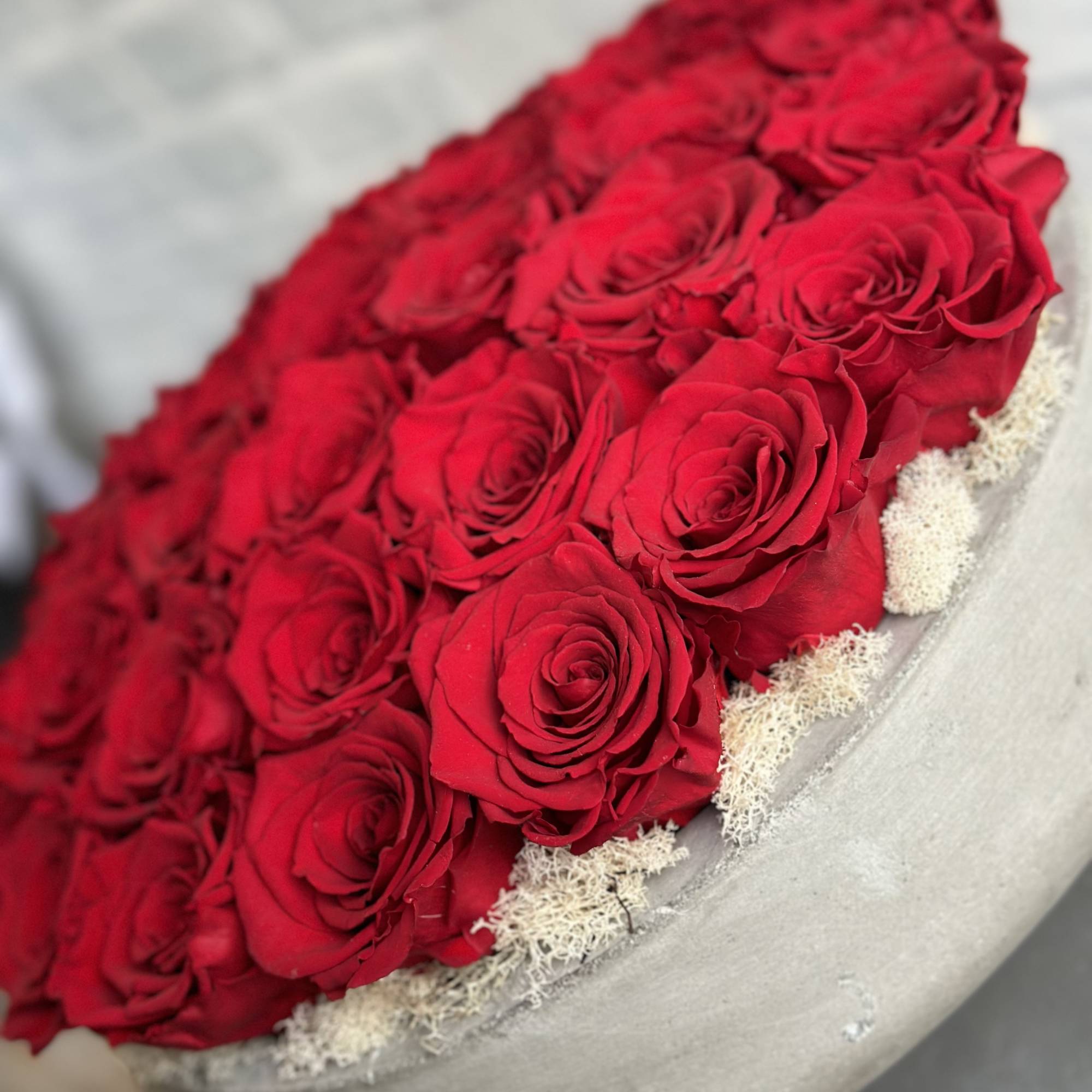 Bouquet of red roses in a gray hatbox