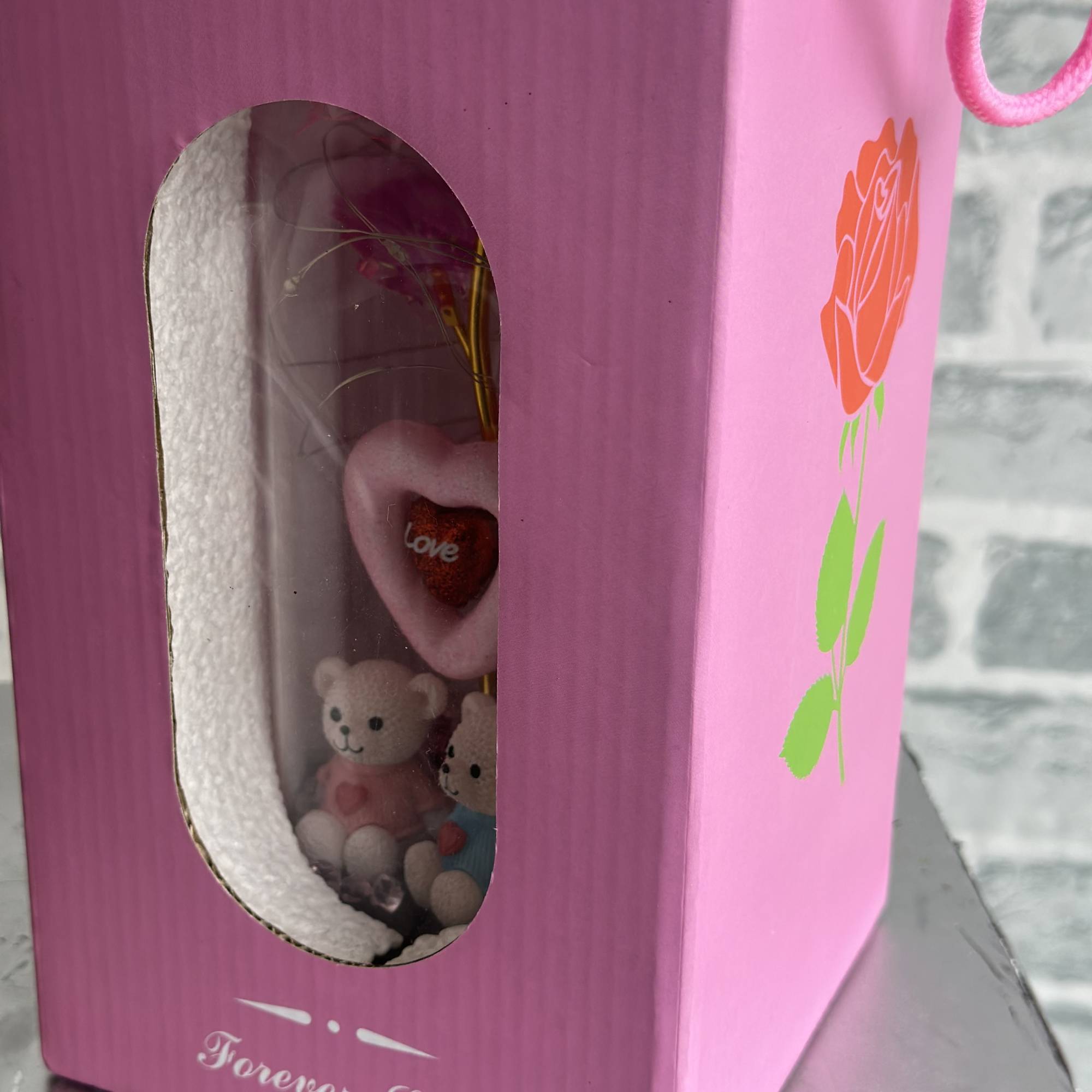 Pink gift box with a heart and teddy bears inside