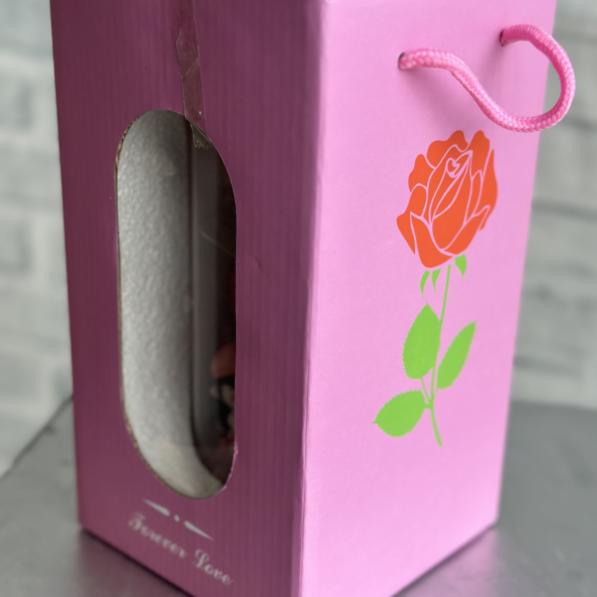Pink gift box with a rose graphic and rope handle