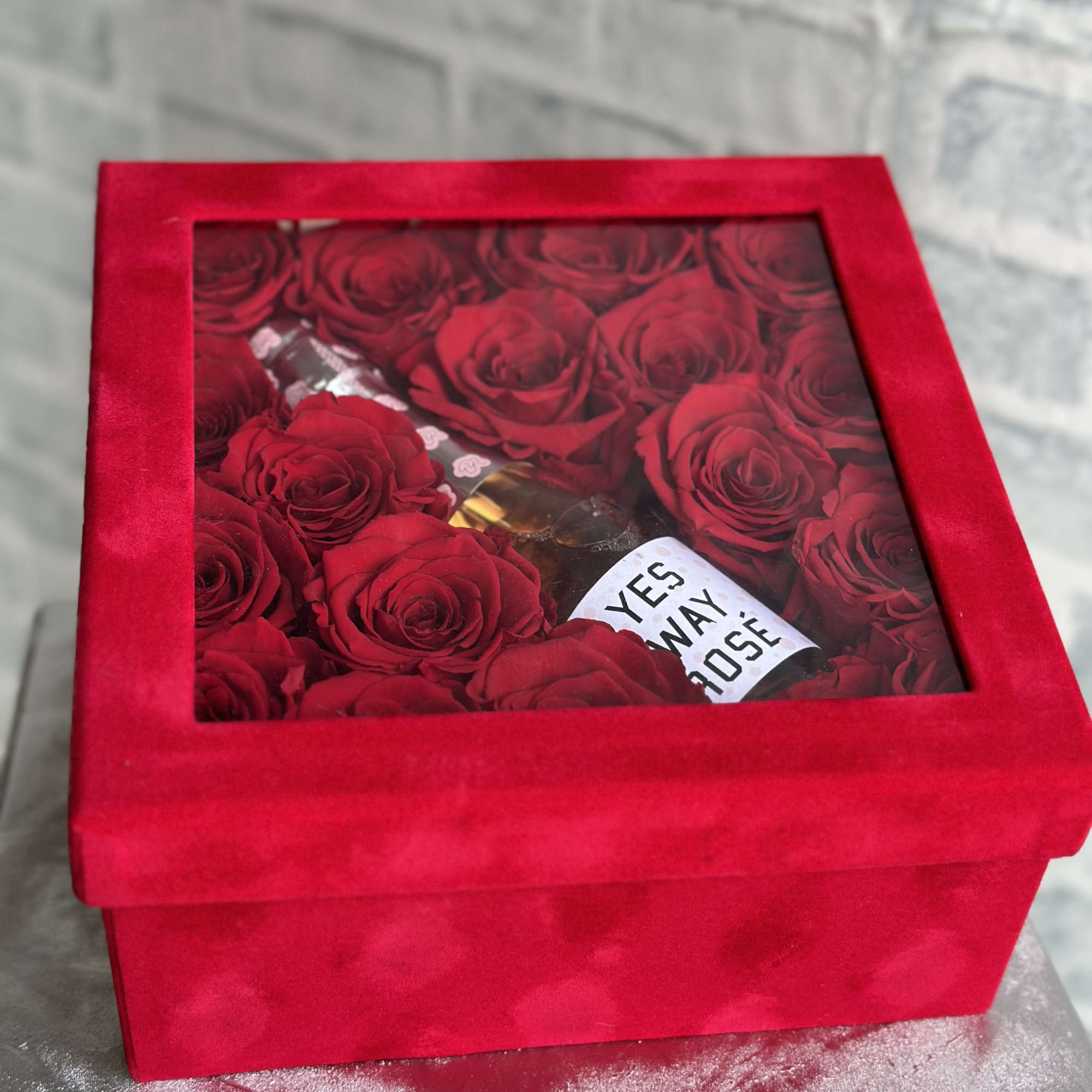 Red roses in a red gift box with a clear window