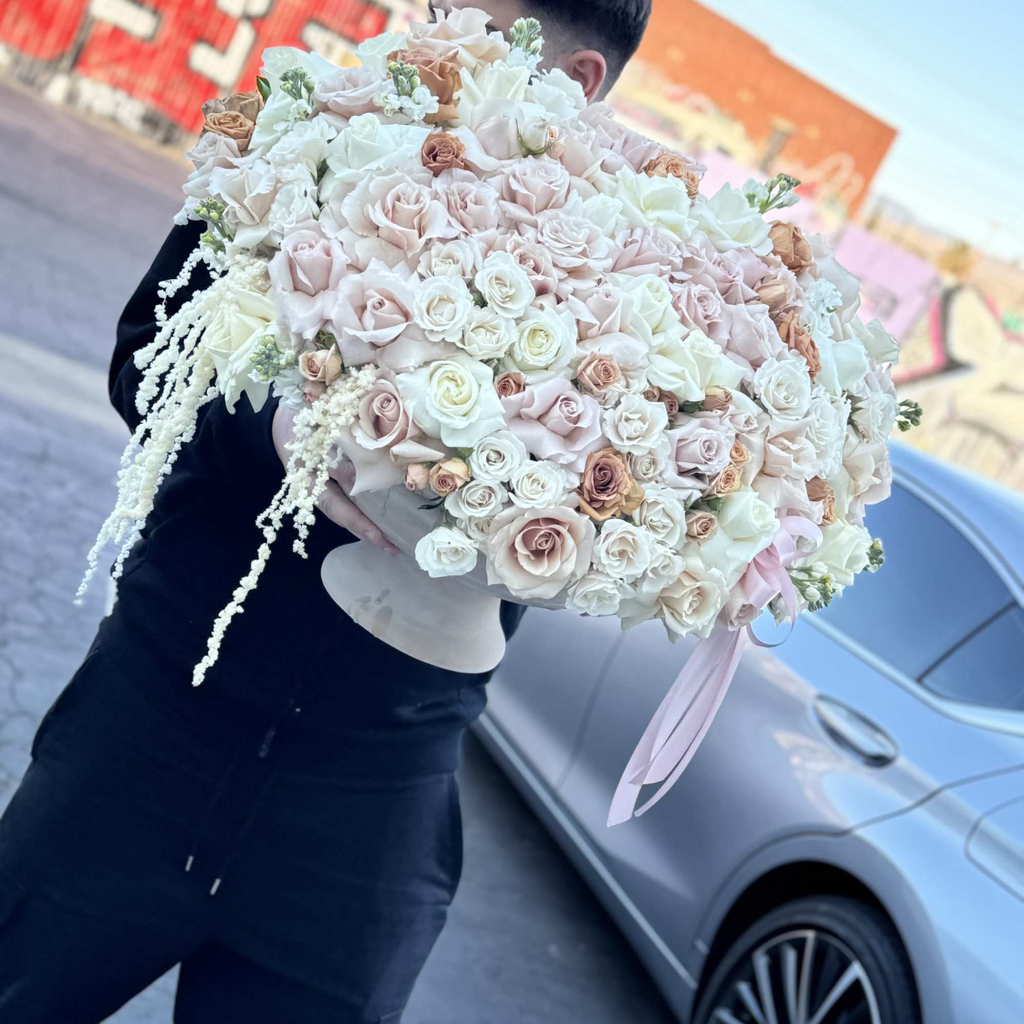 Large bouquet of pale pink and white roses with trailing white accents