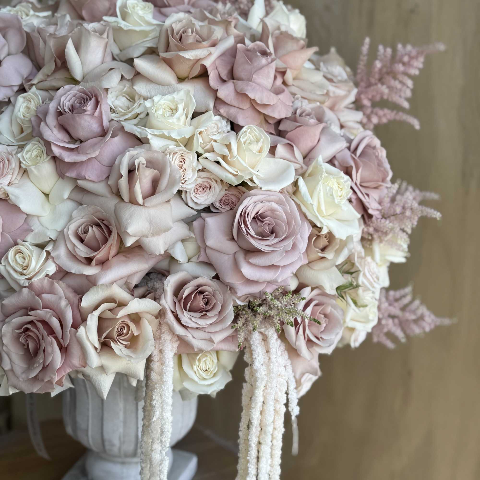 Bouquet of blush and white roses in a pedestal vase