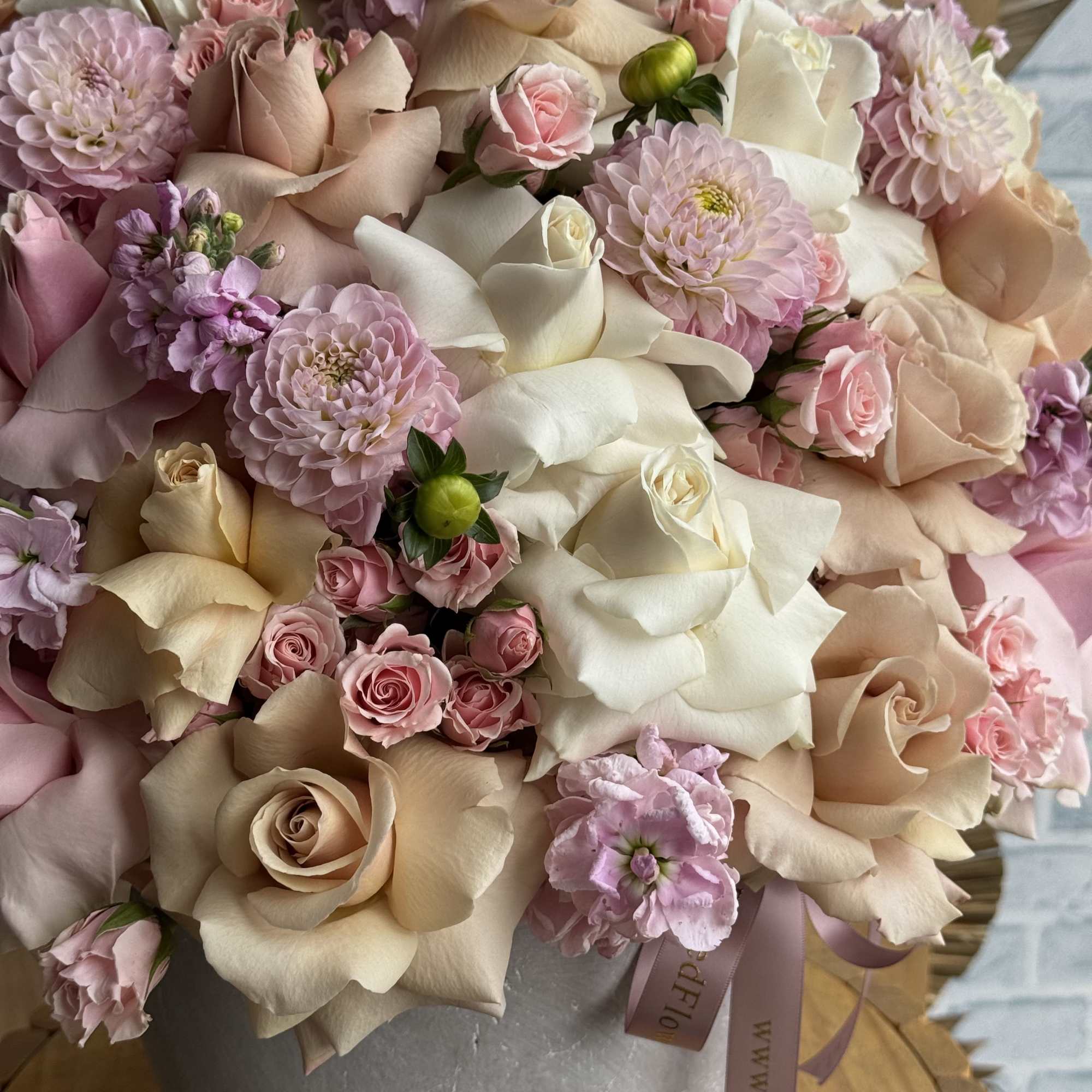 Bouquet of blush and cream roses with pale pink blooms in a gray vase