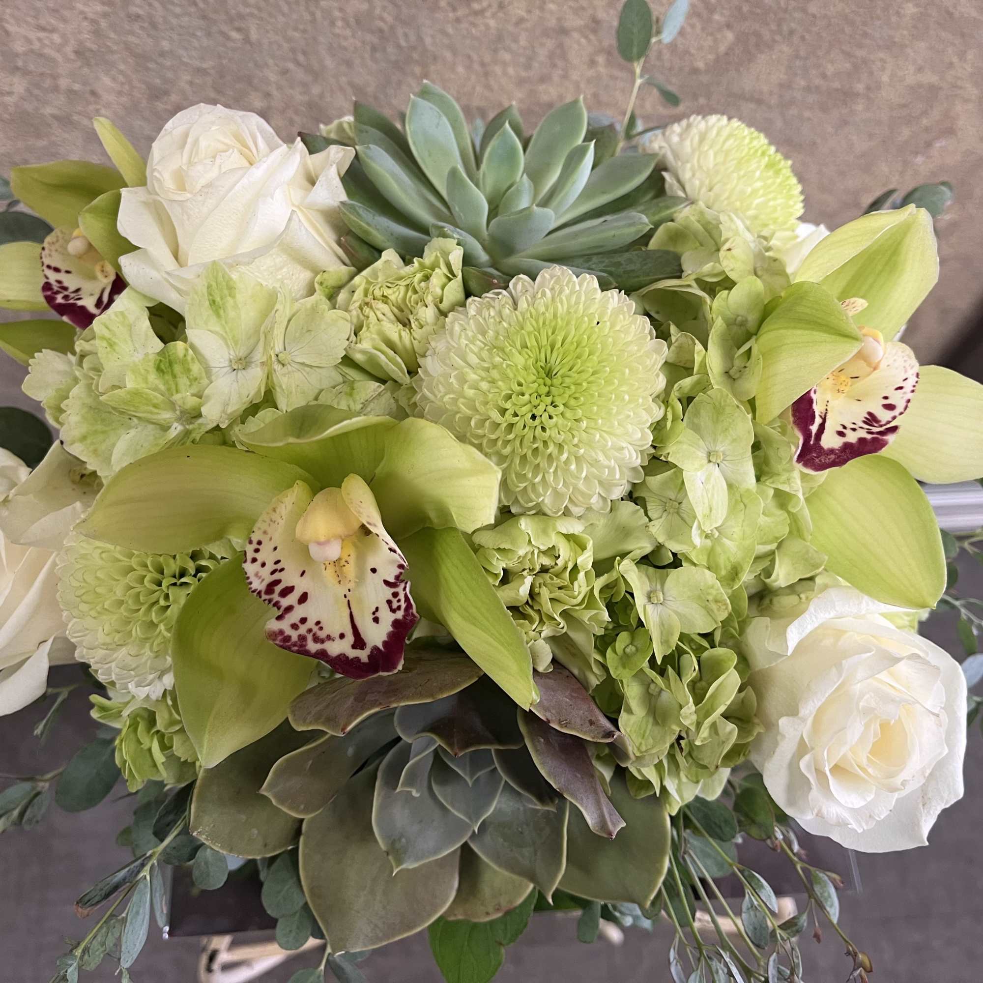 Bouquet of white roses, green orchids, and succulents