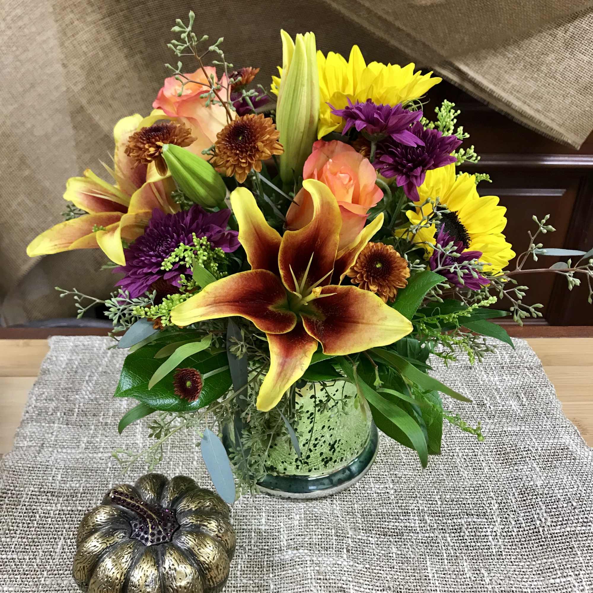 Mixed bouquet with lilies, roses, and chrysanthemums in a glass vase