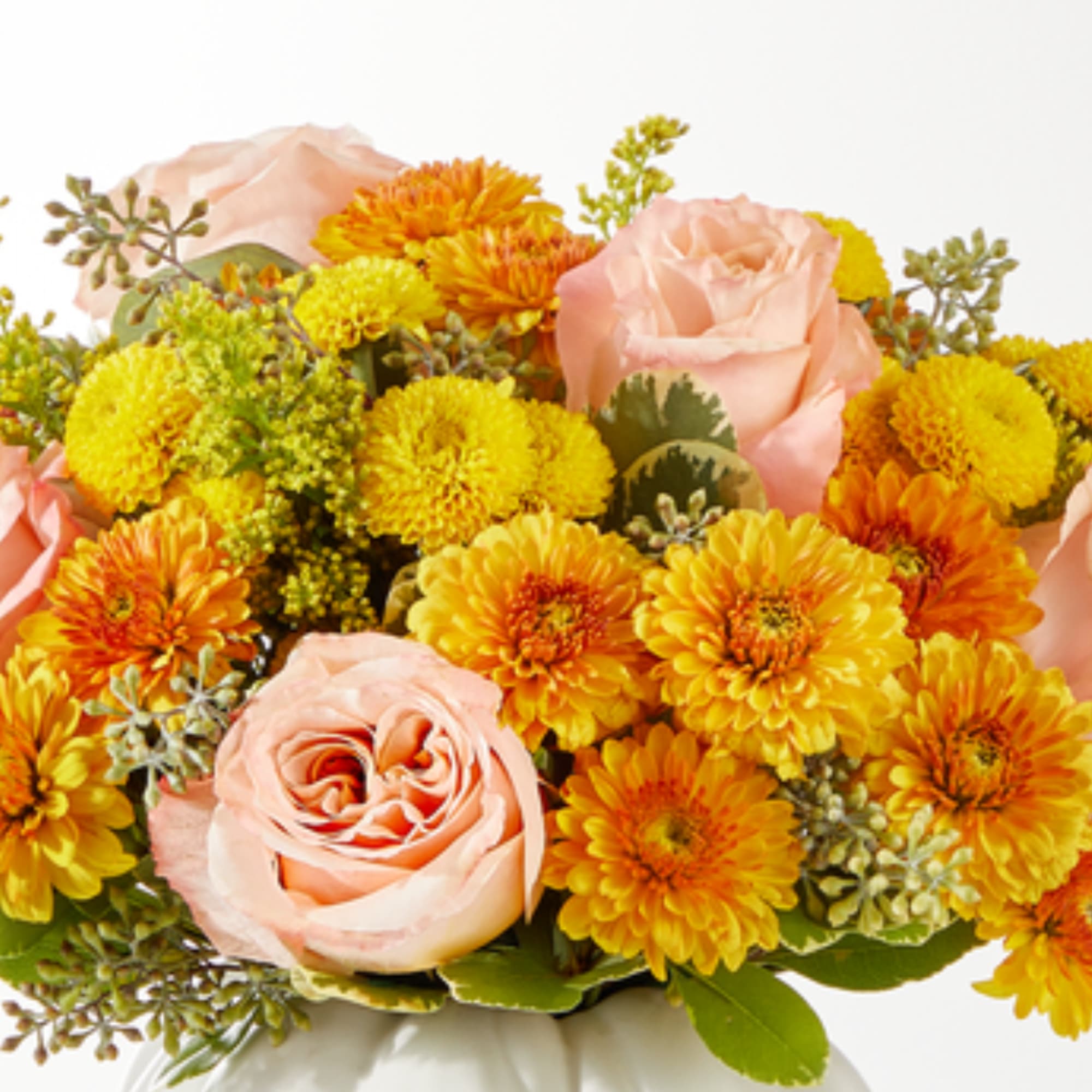 Peach roses and yellow-orange chrysanthemums in a white vase
