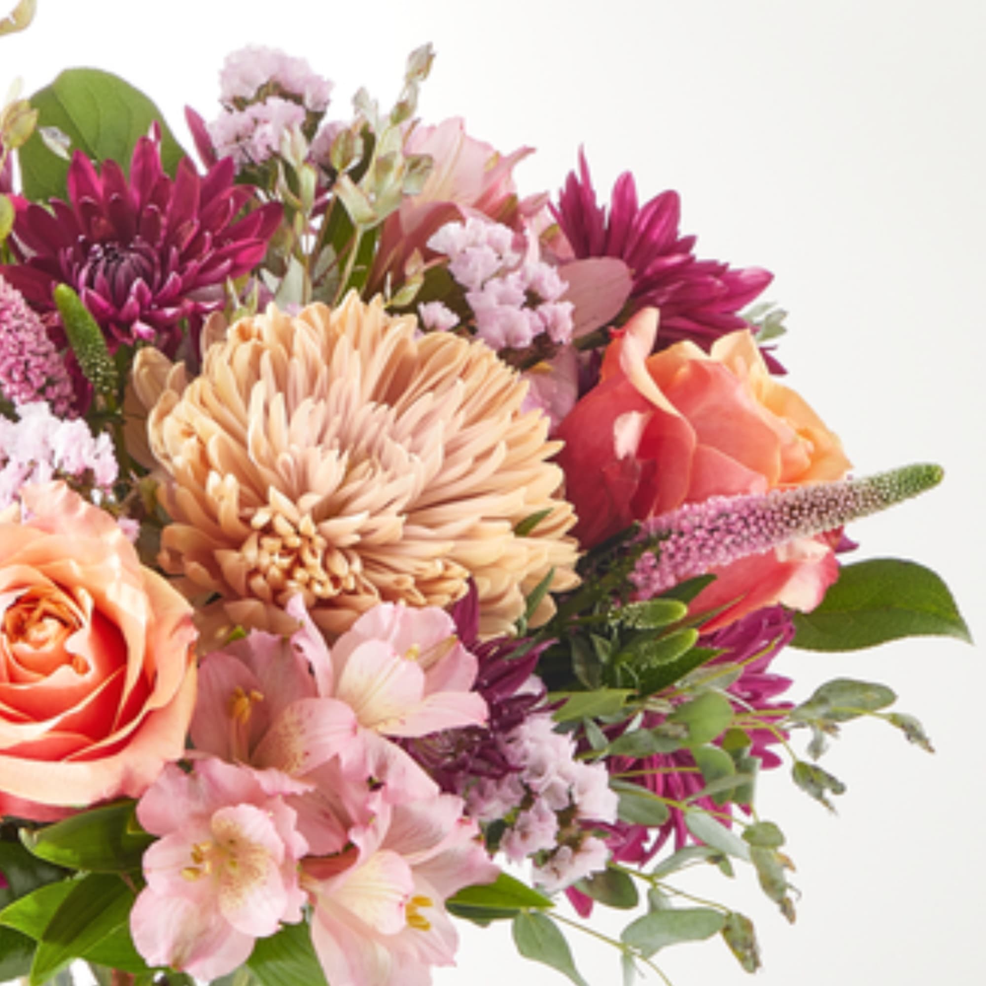 Mixed bouquet with peach roses, pink blooms, and purple flowers