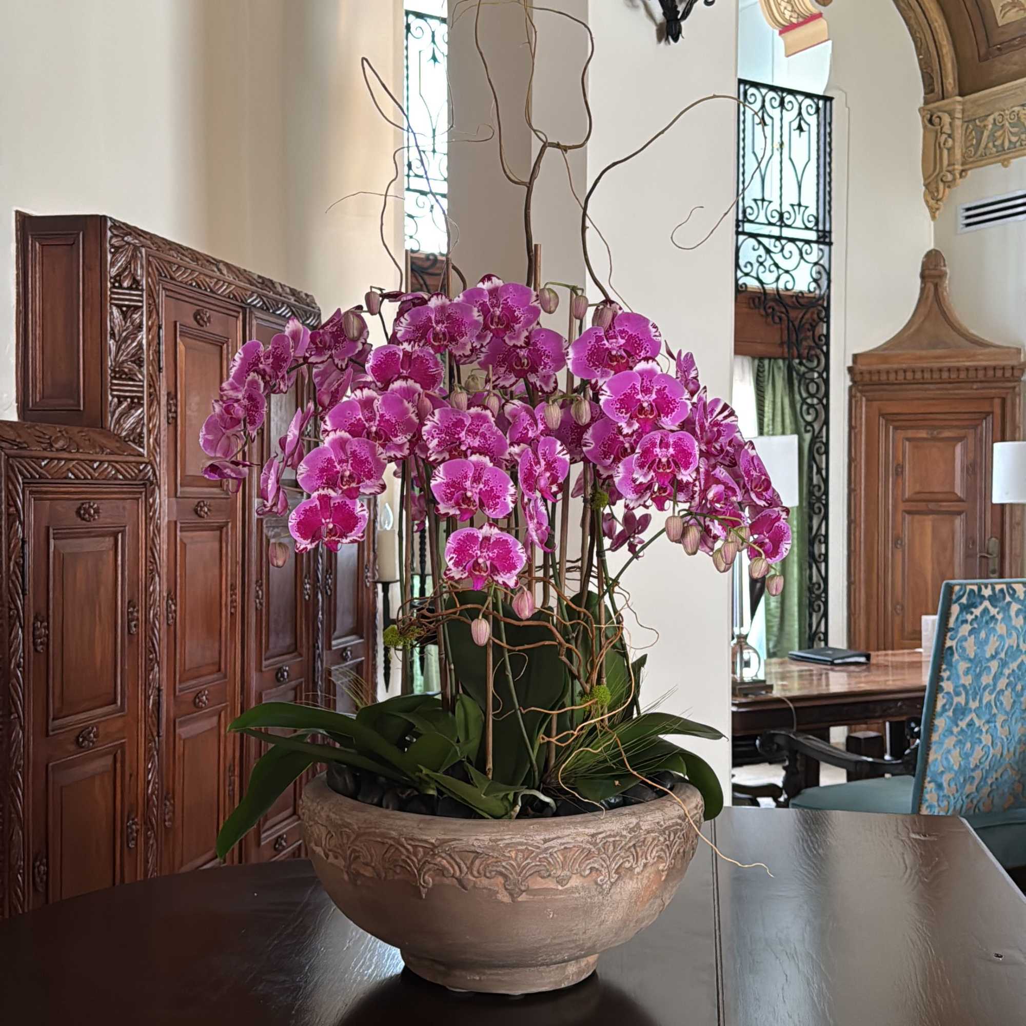 Pink orchids arranged in a decorative bowl on a table