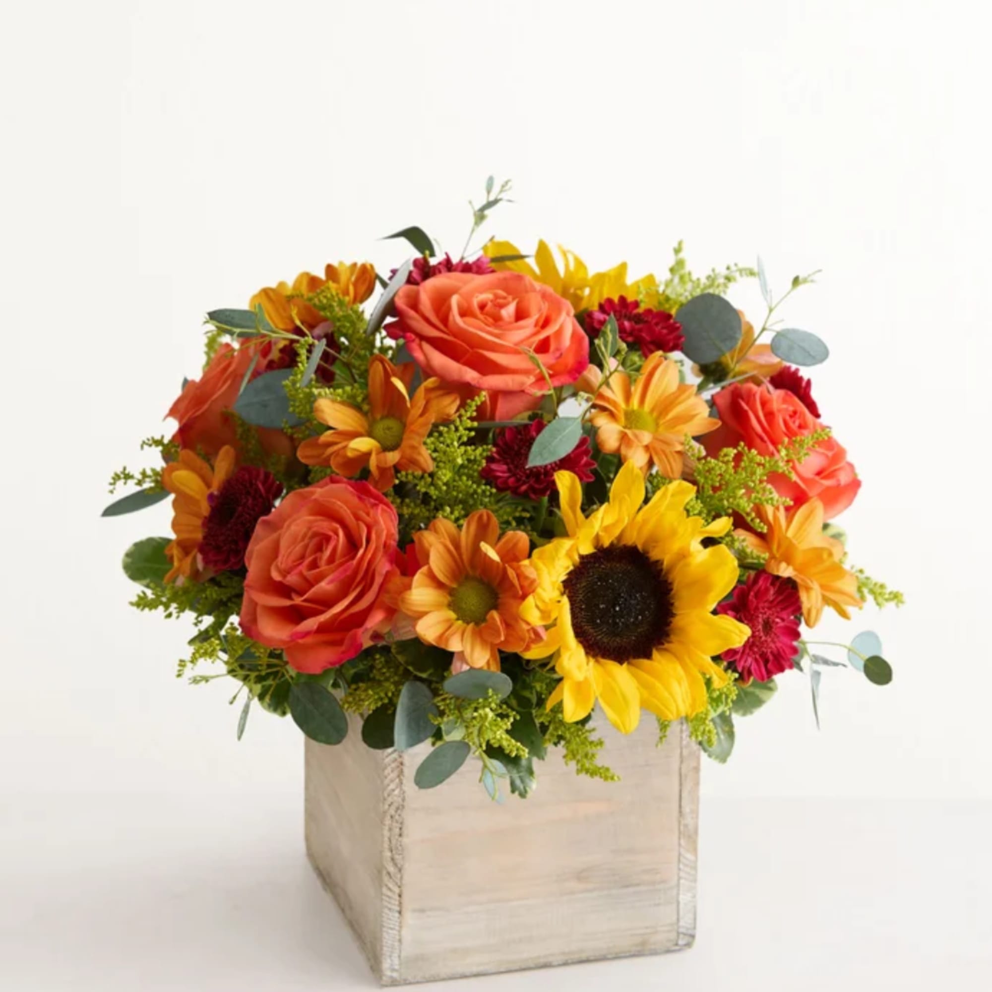 Mixed bouquet of roses, sunflowers, and daisies in a square wooden box
