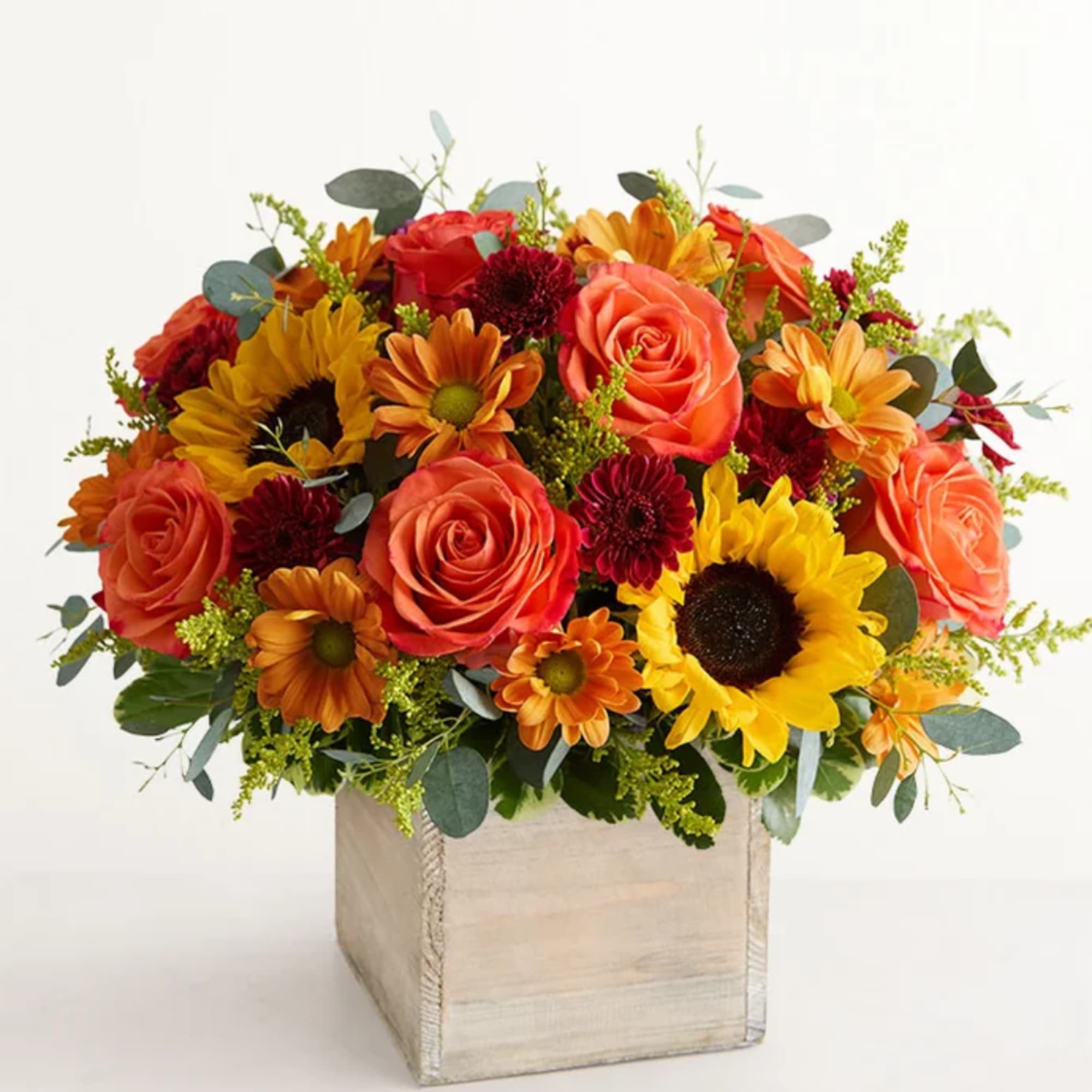 Orange roses and sunflowers in a square wooden box