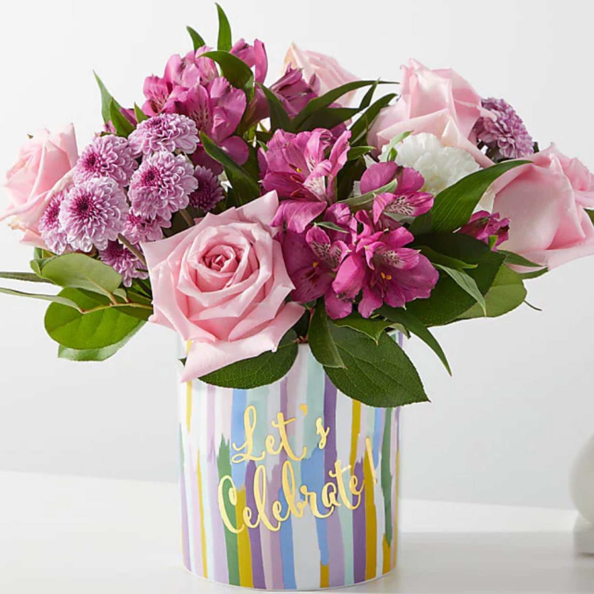 Pink roses and mixed pink flowers in a striped vase