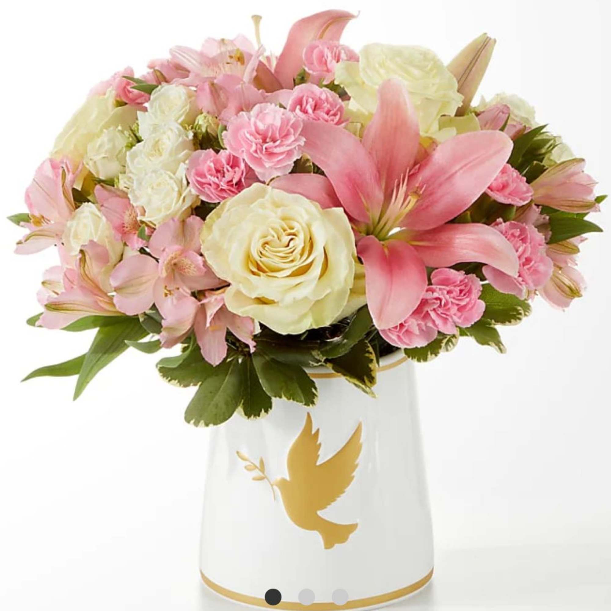 Pink and cream bouquet in a white vase with a gold dove design