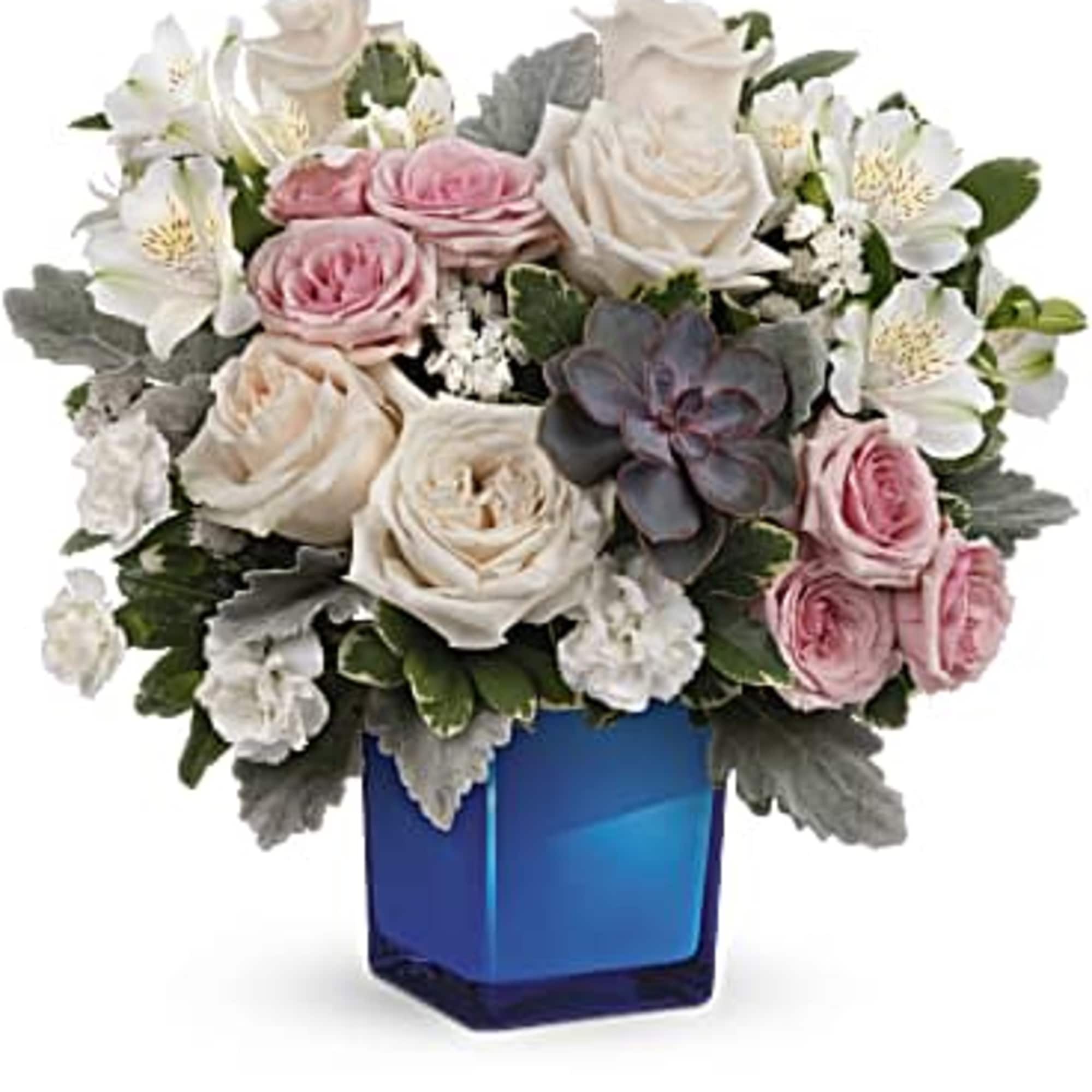 Pink and white roses arranged in a blue glass vase