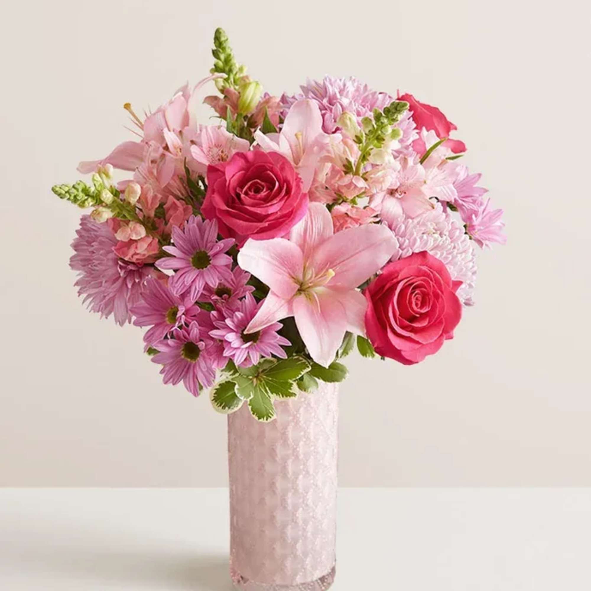 Pink bouquet with roses, lilies, and daisies in a tall vase
