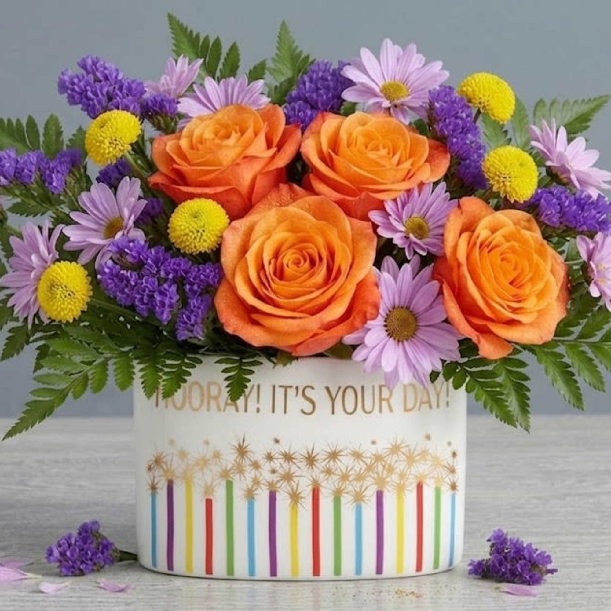 Orange roses crown this Citrus and Spice flower arrangement, making an instant