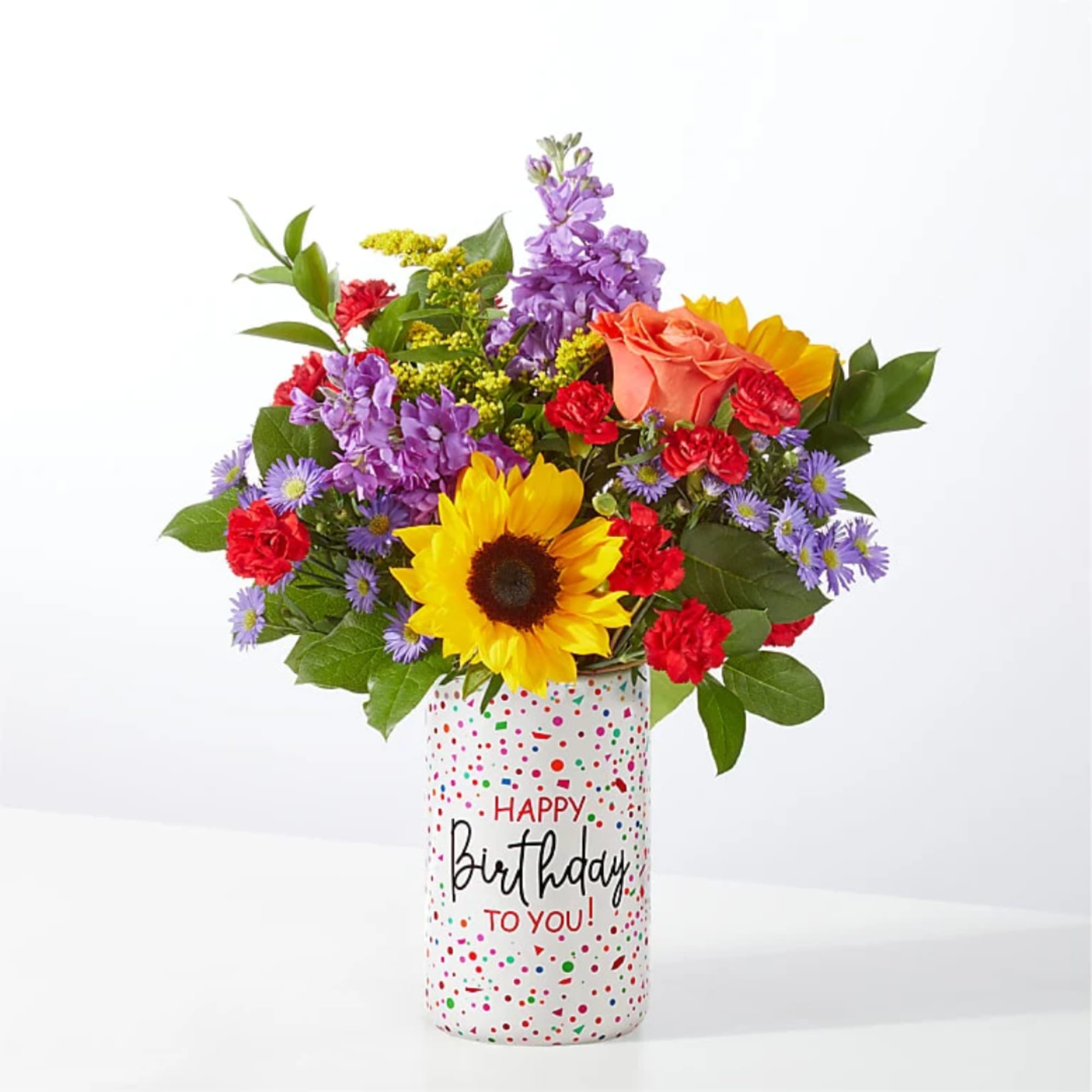 Mixed bouquet in a birthday vase with sunflower, roses, and purple flowers