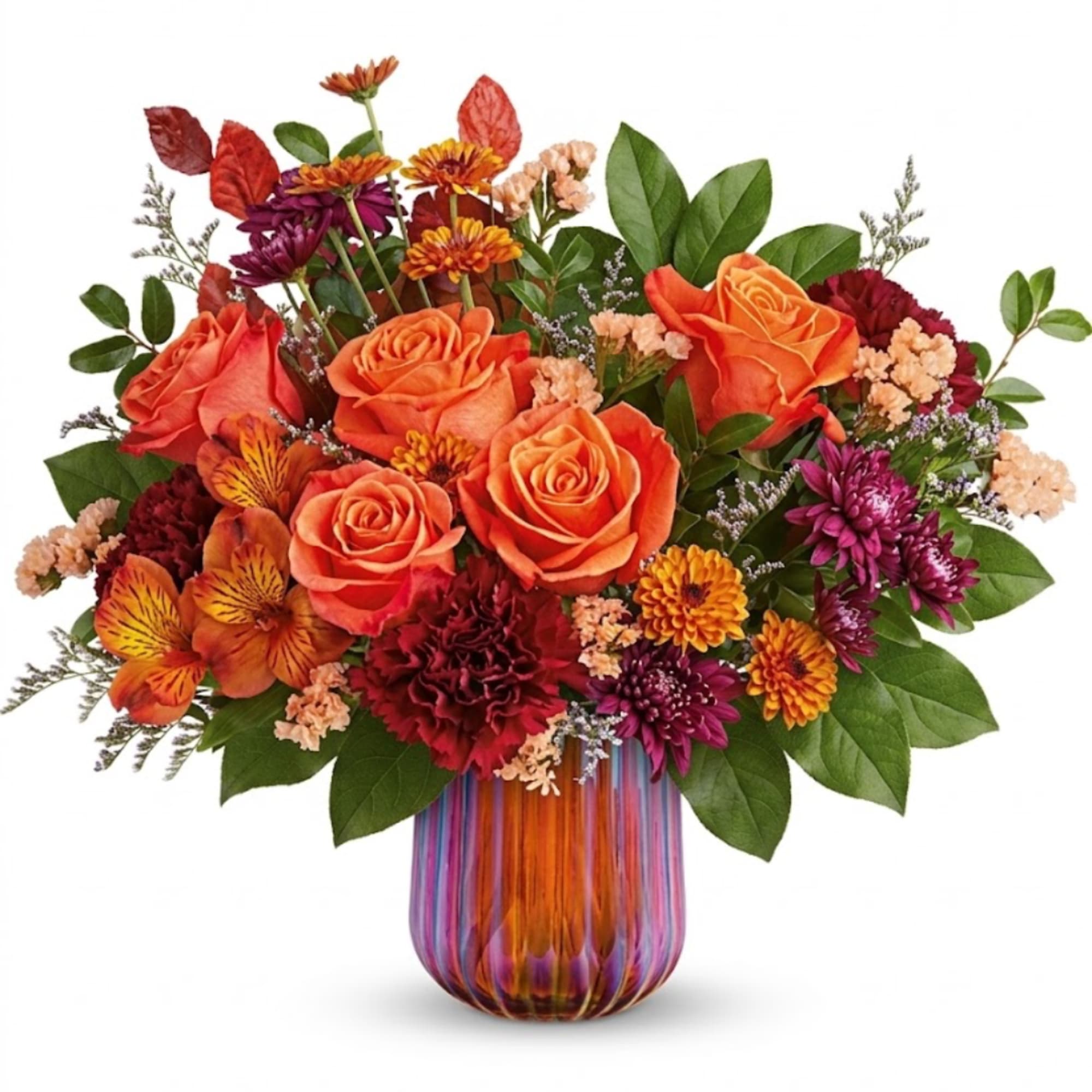 Orange and burgundy flower arrangement in a striped glass vase