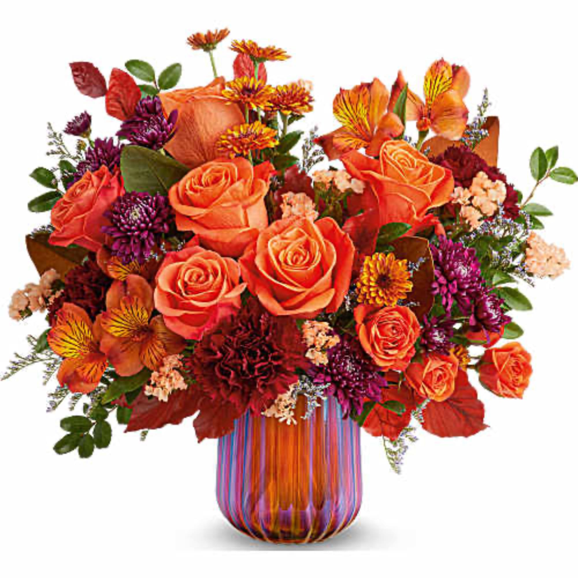 Orange roses and mixed fall flowers in a striped glass vase