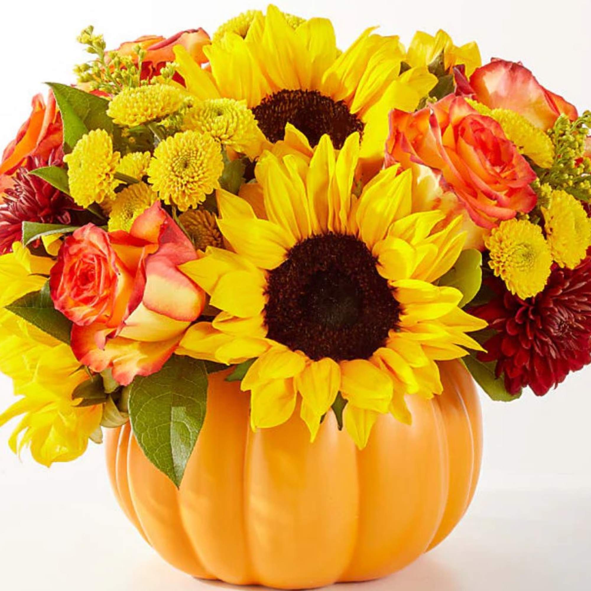 Sunflower and rose arrangement in an orange pumpkin container