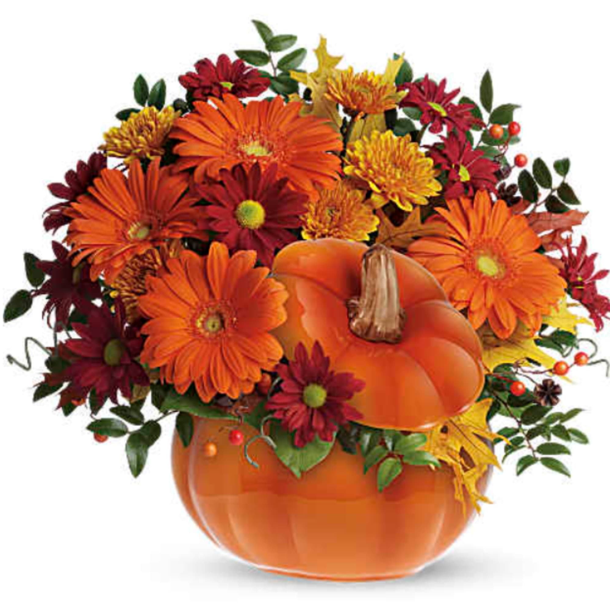 Autumn flower arrangement in a pumpkin-shaped vase with orange and red blooms