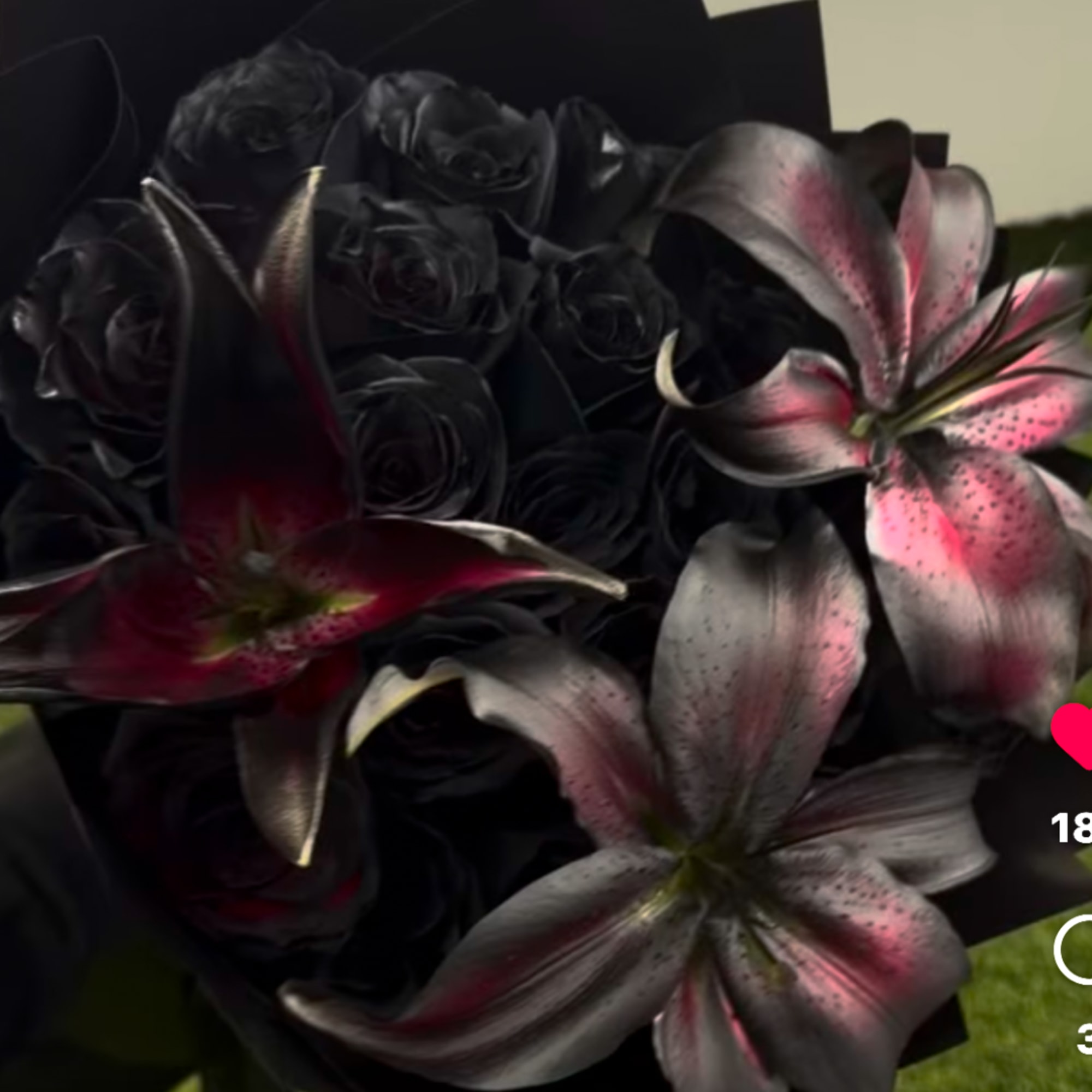Black roses with pink-and-silver lilies in a dark bouquet