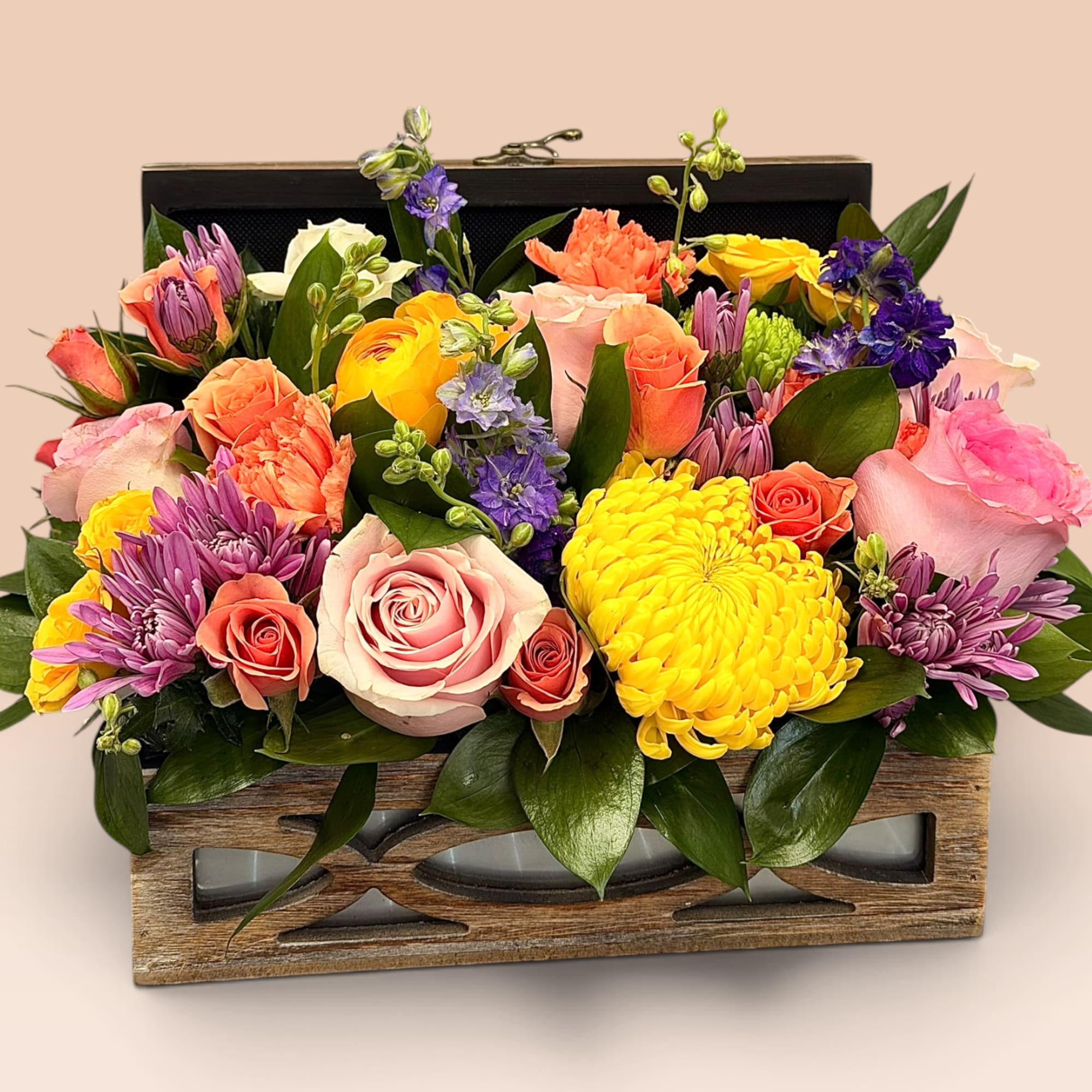 Mixed bouquet in a wooden box with pink, yellow, purple, and coral blooms