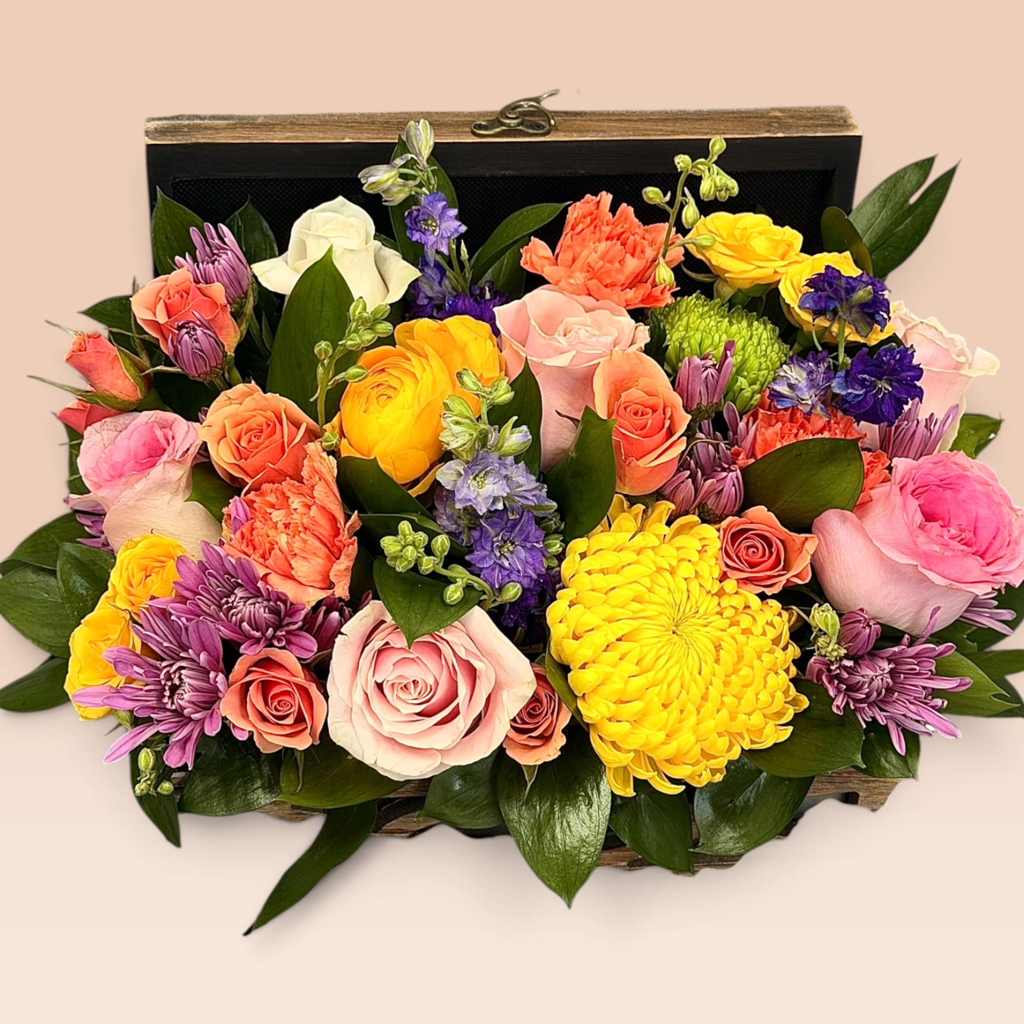 Mixed bouquet in a wooden box with pink, yellow, orange, and purple flowers