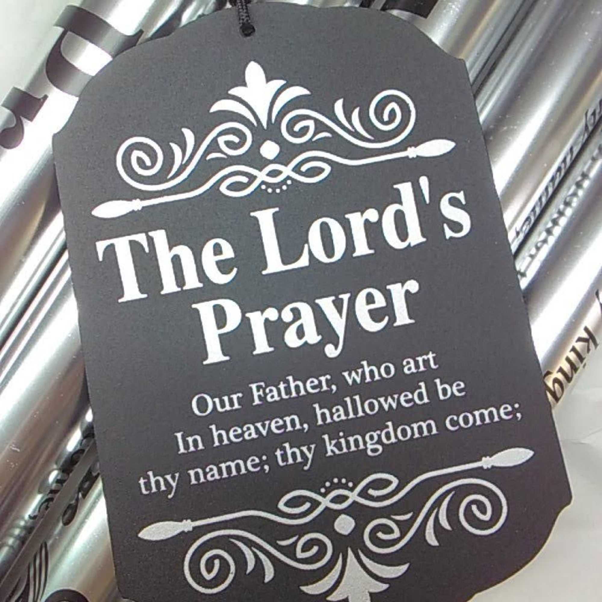Black prayer tag hanging on silver wrapped gift packaging