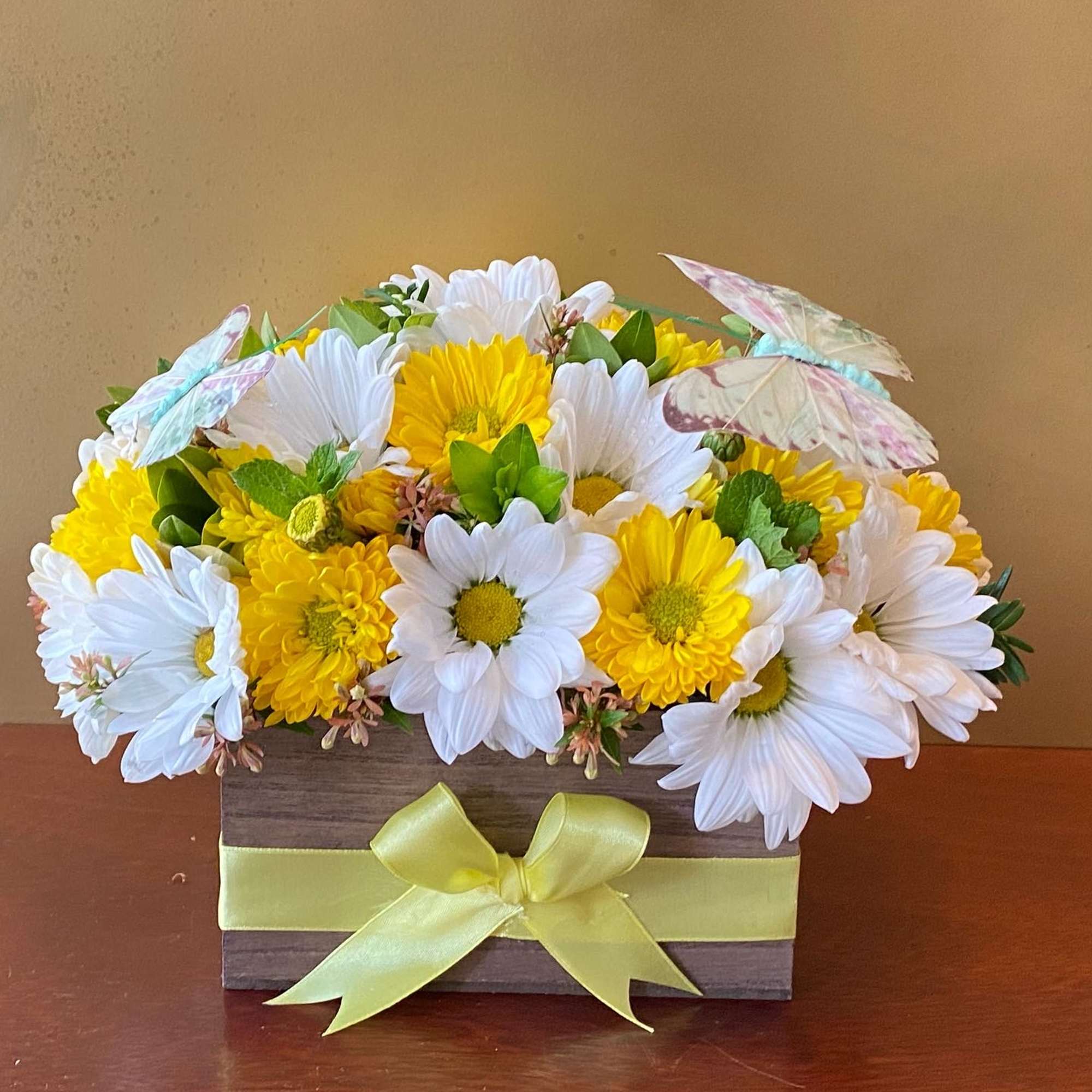 Yellow and white daisy bouquet in a wooden box with a ribbon