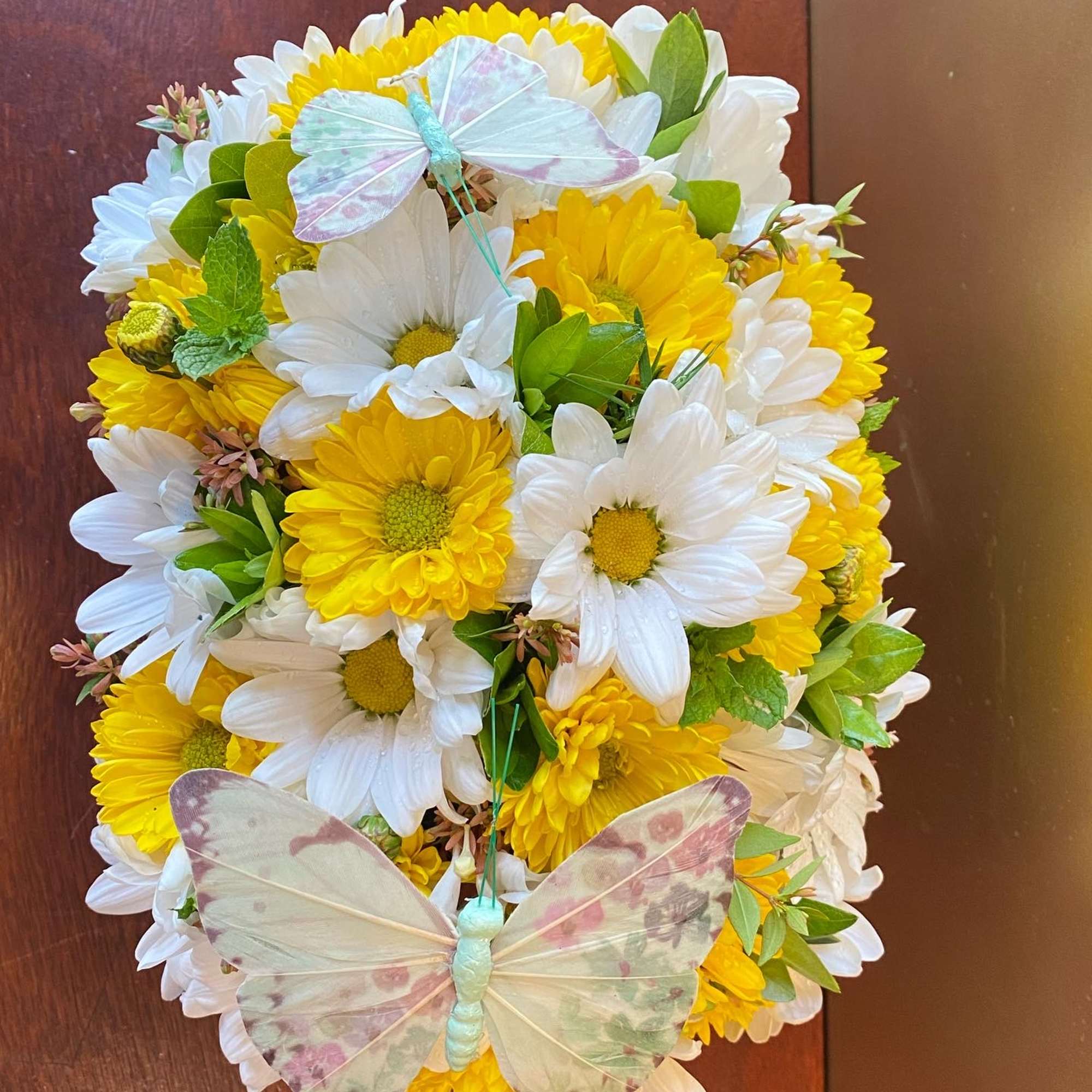 Yellow and white daisy bouquet with butterfly decorations