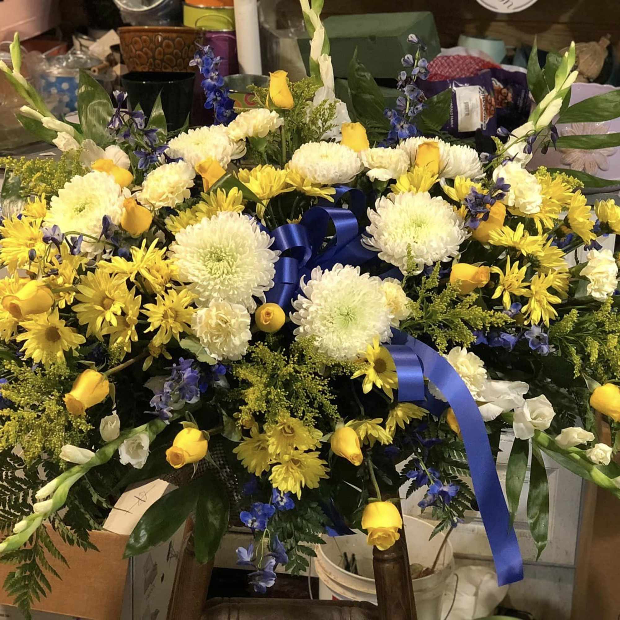 Large yellow and white floral spray with blue ribbon